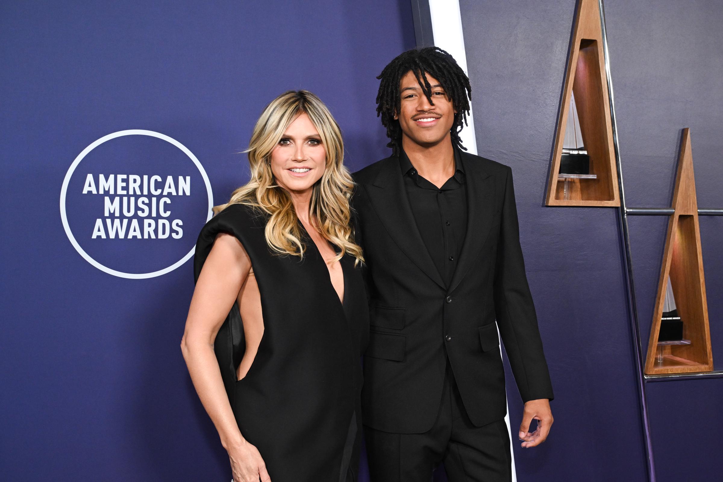 Heidi Klum posiert mit ihrem 19-jährigen Sohn Henry Samuel auf dem lila Teppich der AMAs 2025. Das schwarz gekleidete Mutter-Sohn-Duo sorgte für einen koordinierten und auffälligen Auftritt.