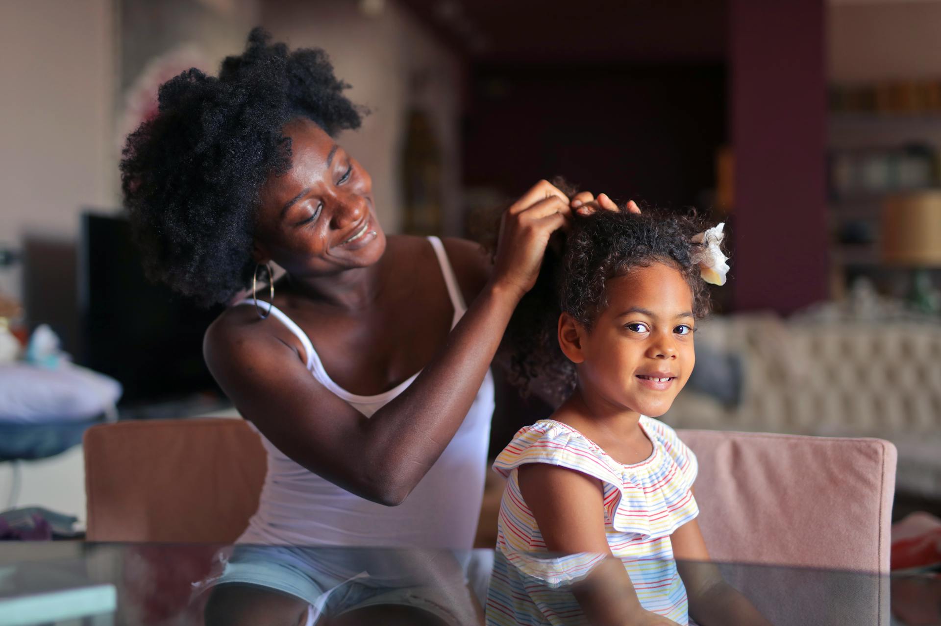 Frau frisiert die Haare ihrer Tochter | Quelle: Pexels