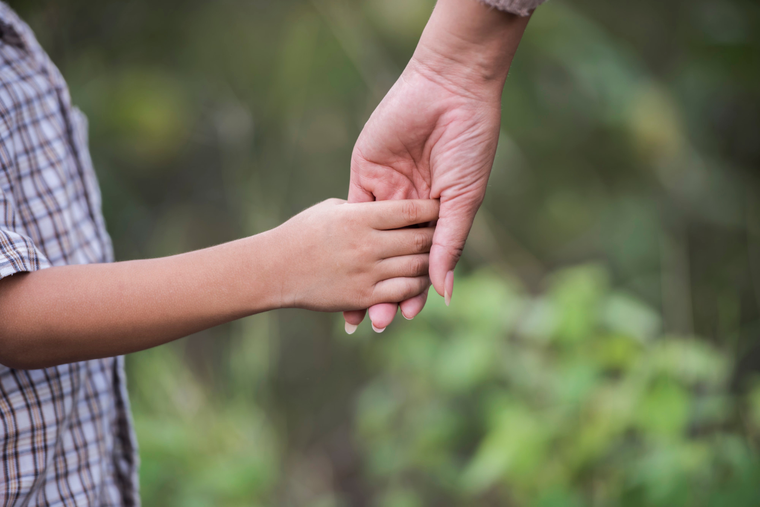 Nahaufnahme einer Mutter, die die Hand ihres Sohnes hält | Quelle: Freepik