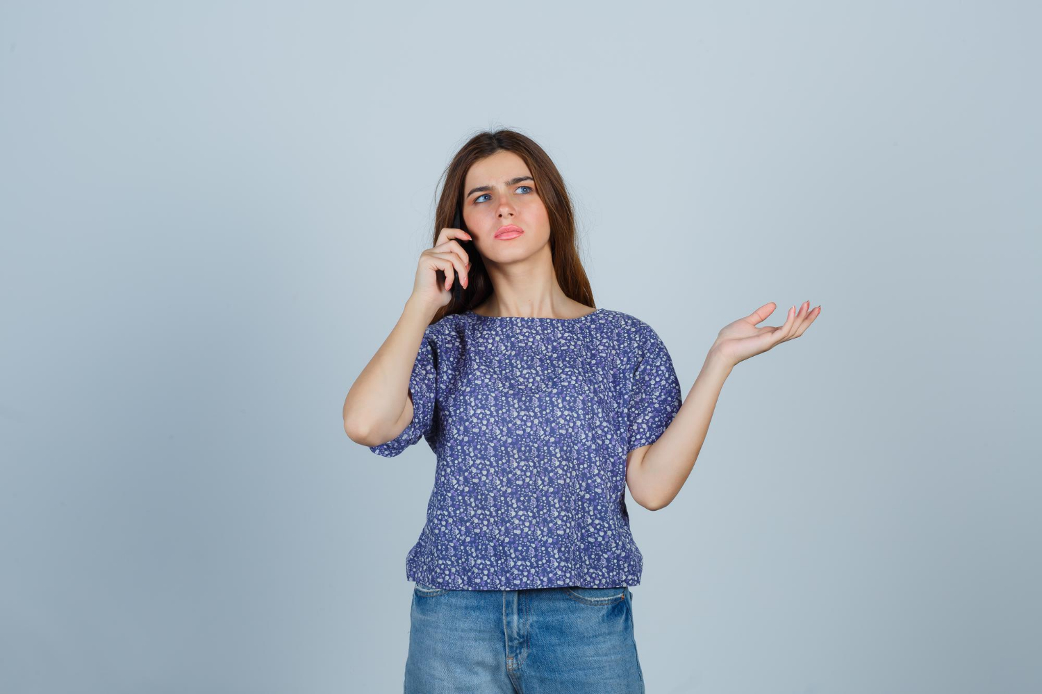 Eine frustrierte junge Frau beim Telefonieren | Quelle: Freepik