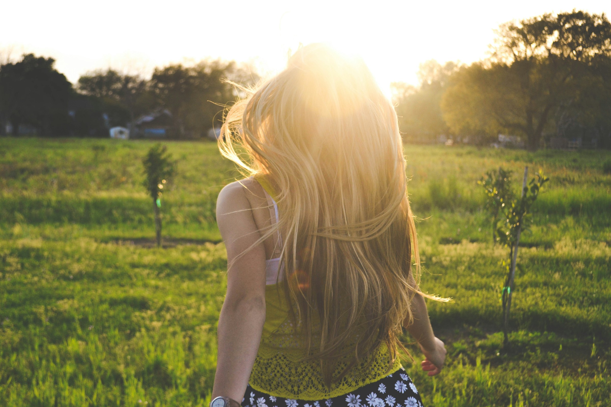 Eine Frau, die während der goldenen Stunde auf einem Feld läuft | Quelle: Unsplash