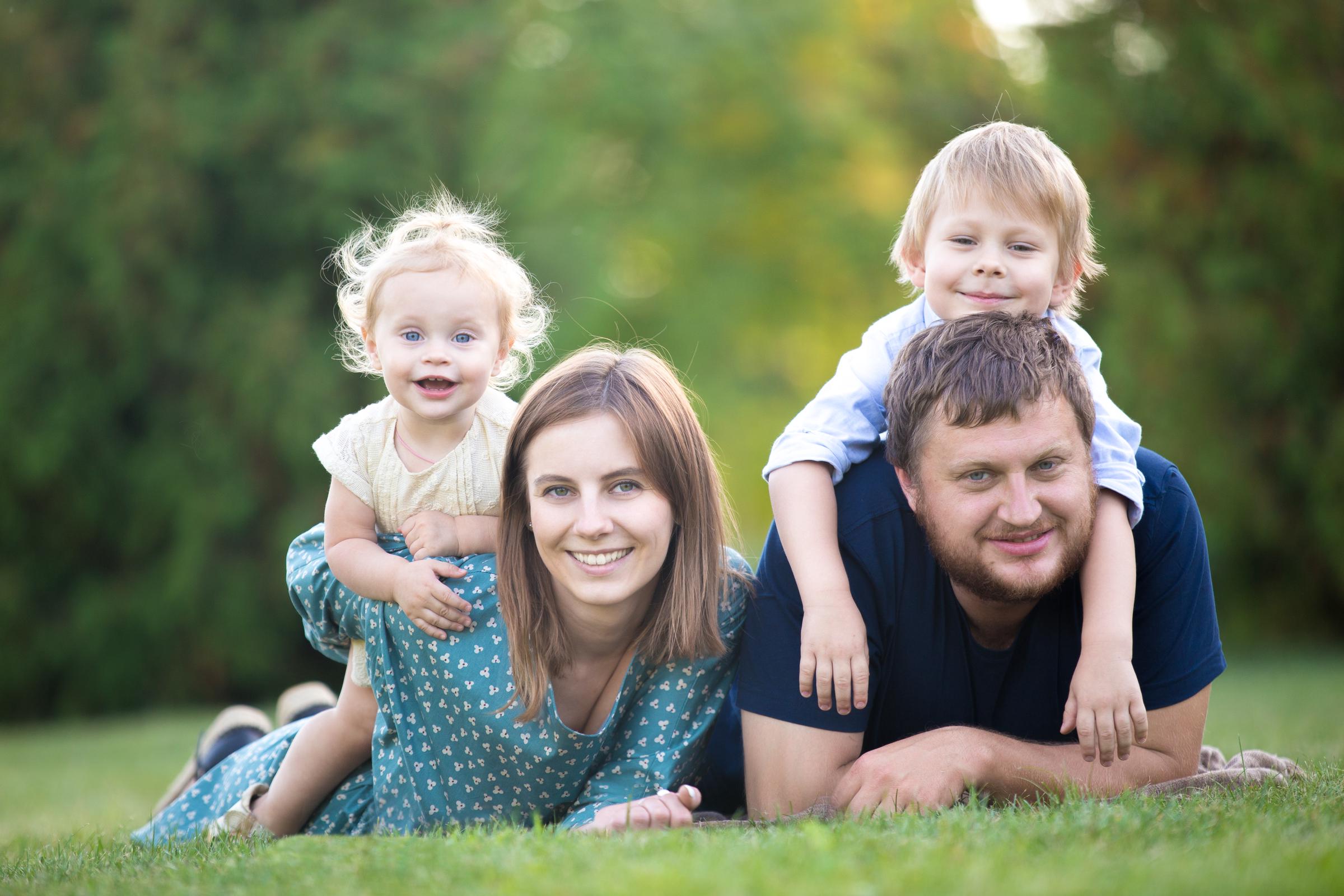 Eltern mit ihren beiden Kindern im Freien | Quelle: FreePik