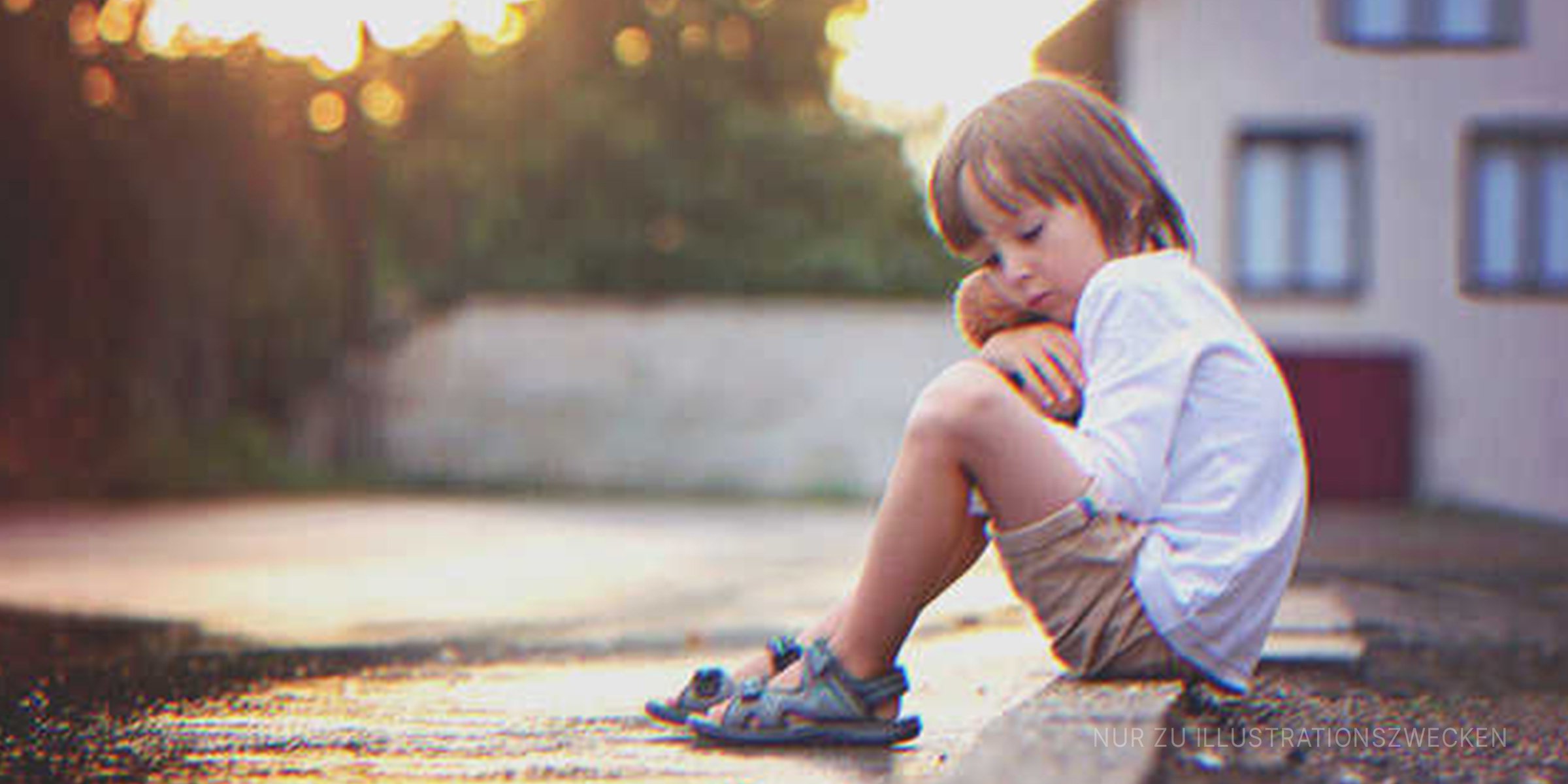 Ein trauriger Junge auf einem Bürgersteig. | Quelle: Shutterstock