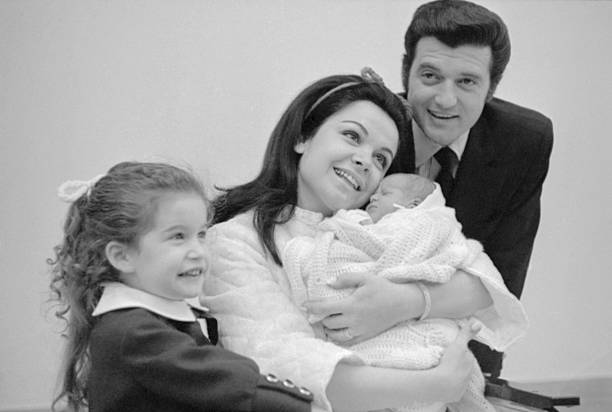 Annette Funicello kuschelt mit ihrem neugeborenen Sohn Jack Jr. im St. Joseph's Hospital, zusammen mit ihrem Mann Jack Gilardi und ihrer Tochter Gina, am 13. Februar 1970. | Quelle: Getty Images