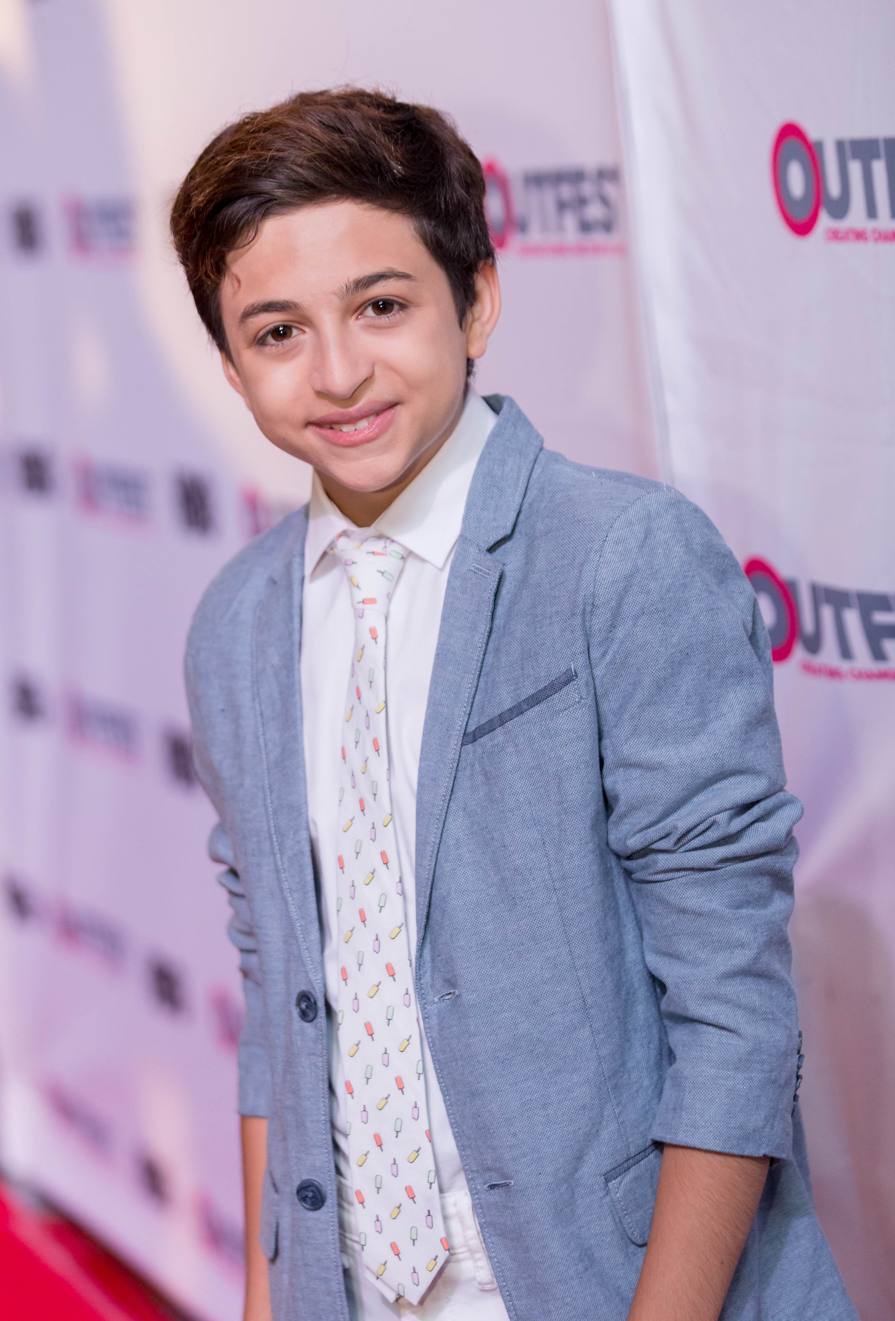 J.J. Totah nimmt an der Abschlussgala von „Other People“ beim Outfest Los Angeles in Los Angeles, Kalifornien, teil und trägt dabei einen hellblauen Blazer, ein weißes Hemd und eine gemusterte Krawatte. | Quelle: Getty Images