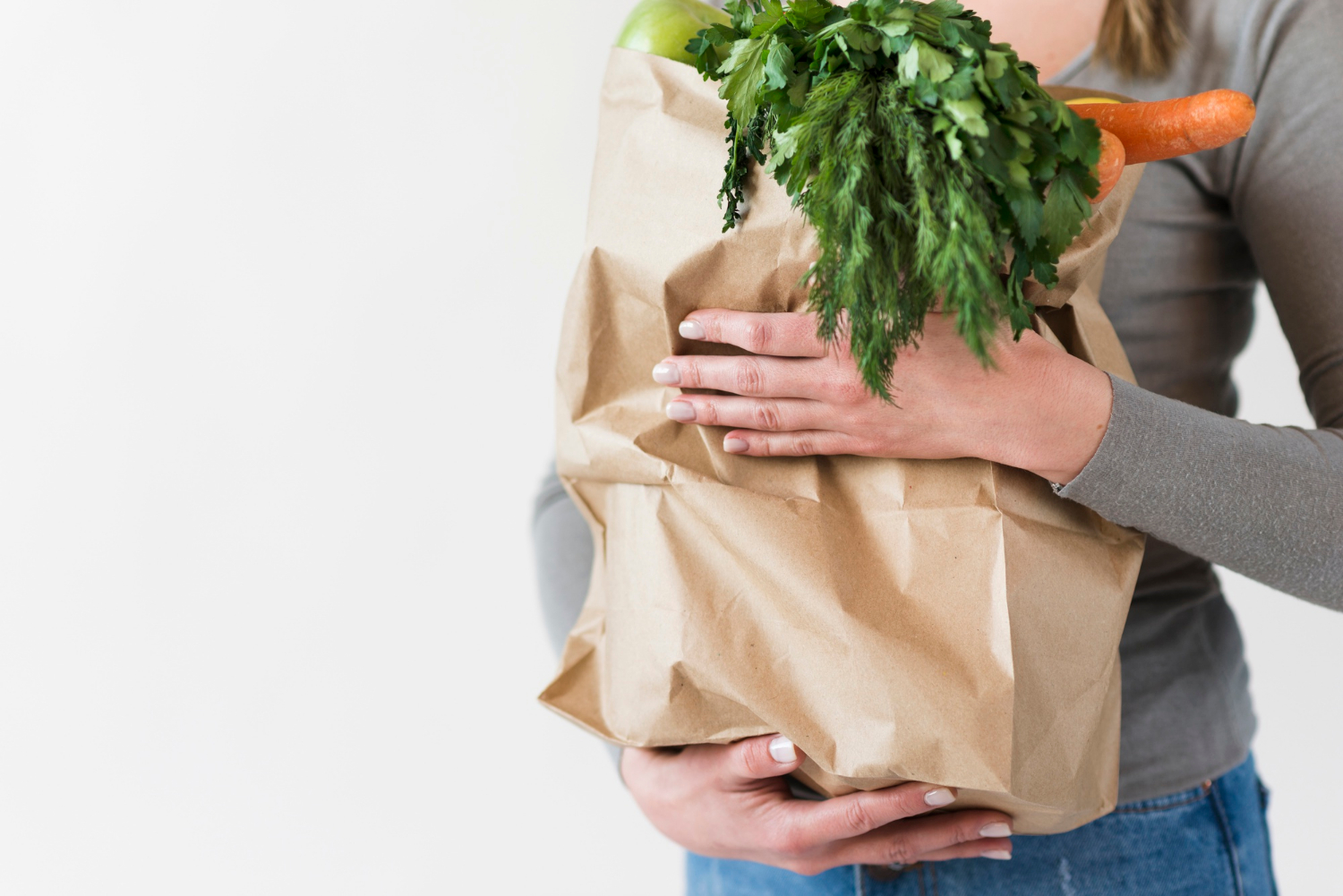 Eine Frau hält eine Tüte mit Lebensmitteln | Quelle: Freepik