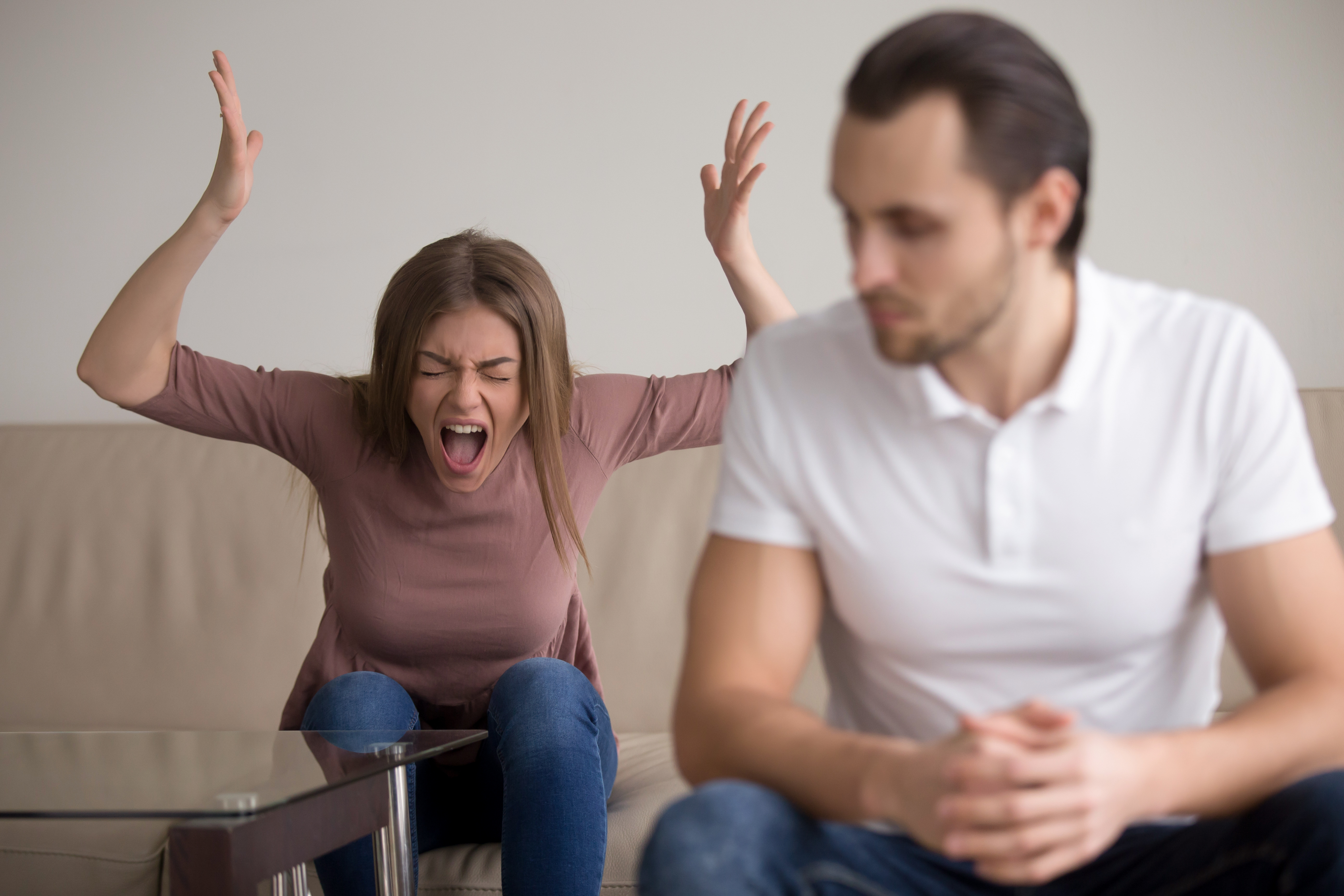 Eine schreiende Frau, die hinter einem Mann sitzt | Quelle: Shutterstock