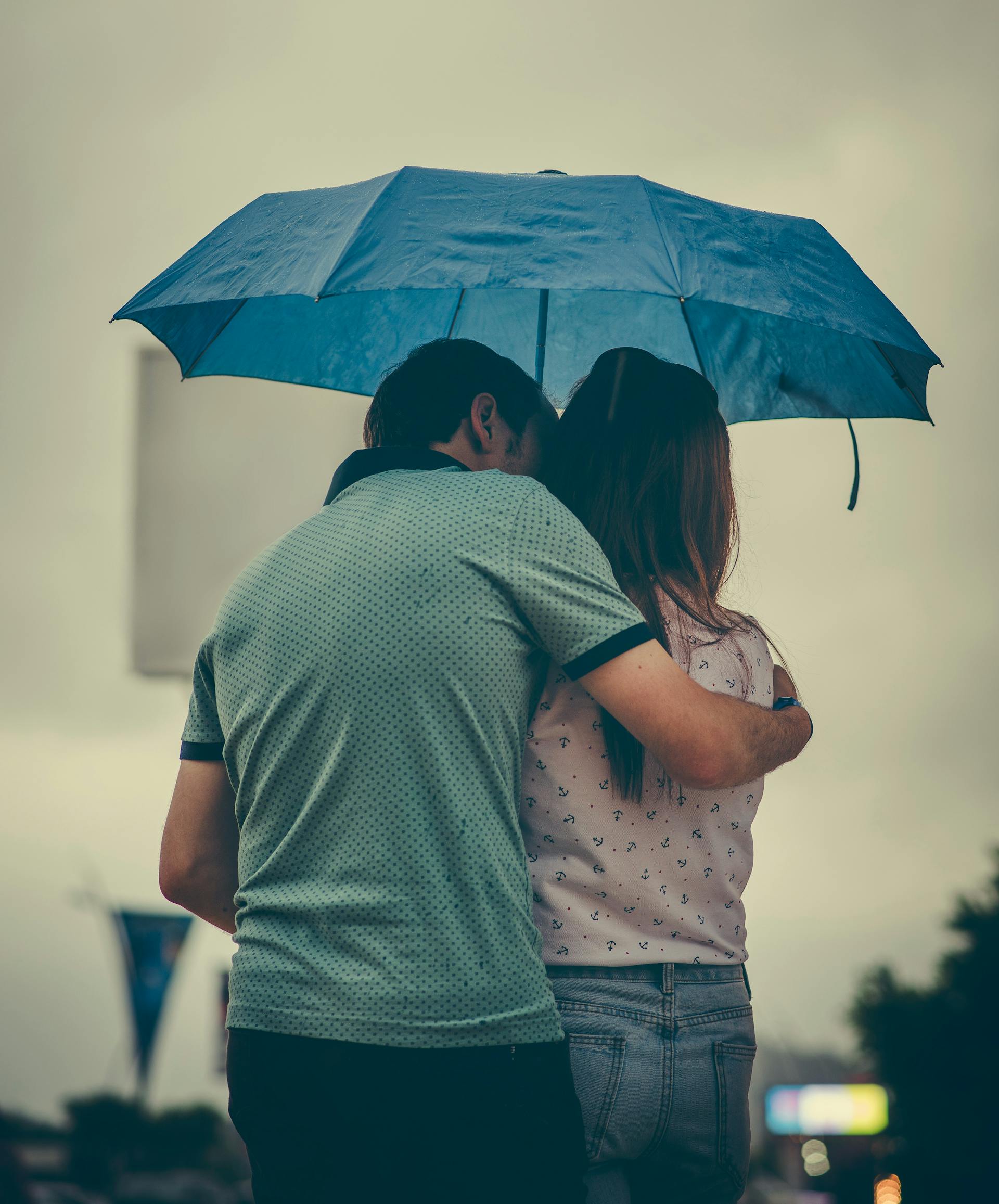 Ein Paar steht unter einem Regenschirm | Quelle: Pexels