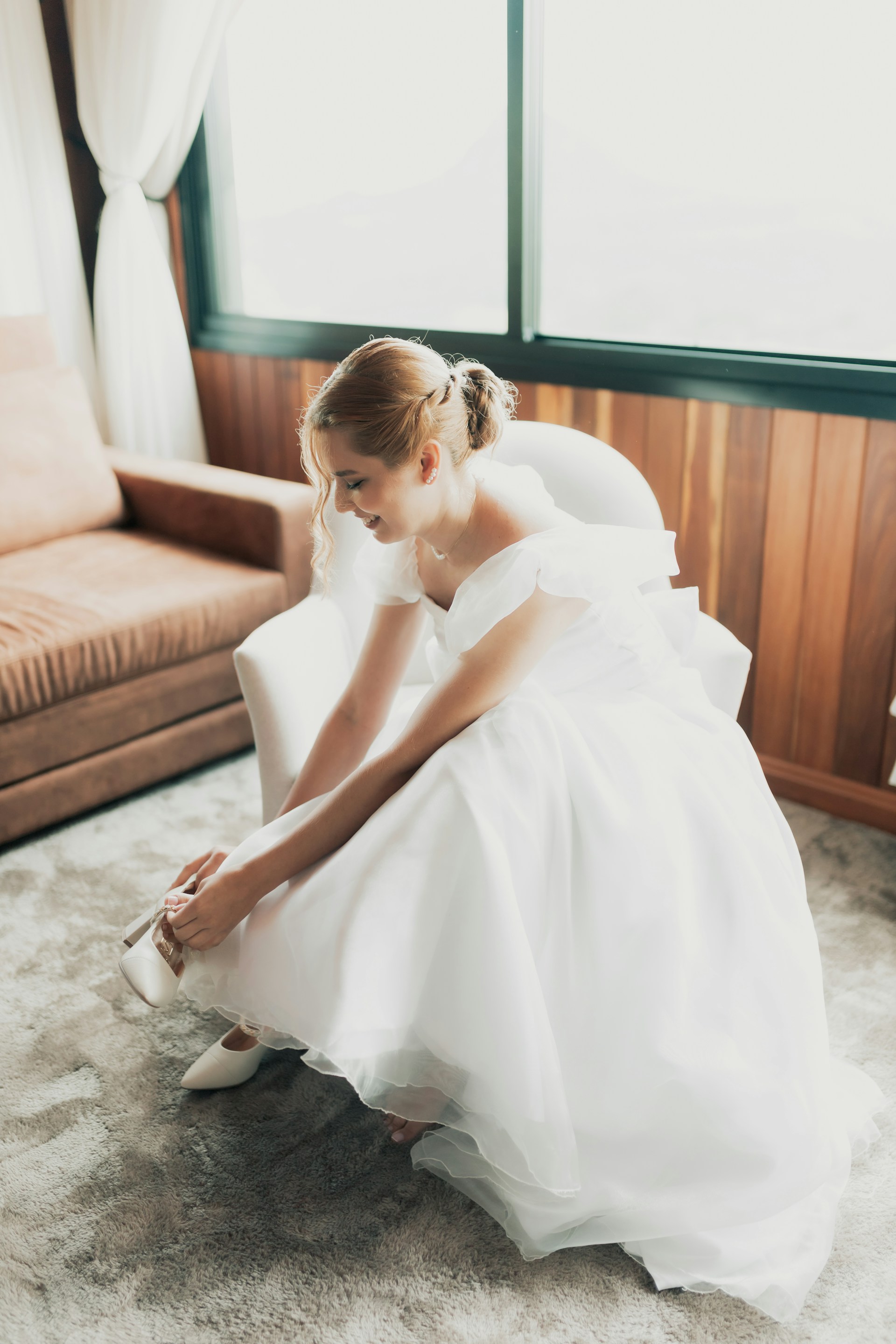 Eine Braut lacht, während sie ihren Schuh repariert | Quelle: Unsplash