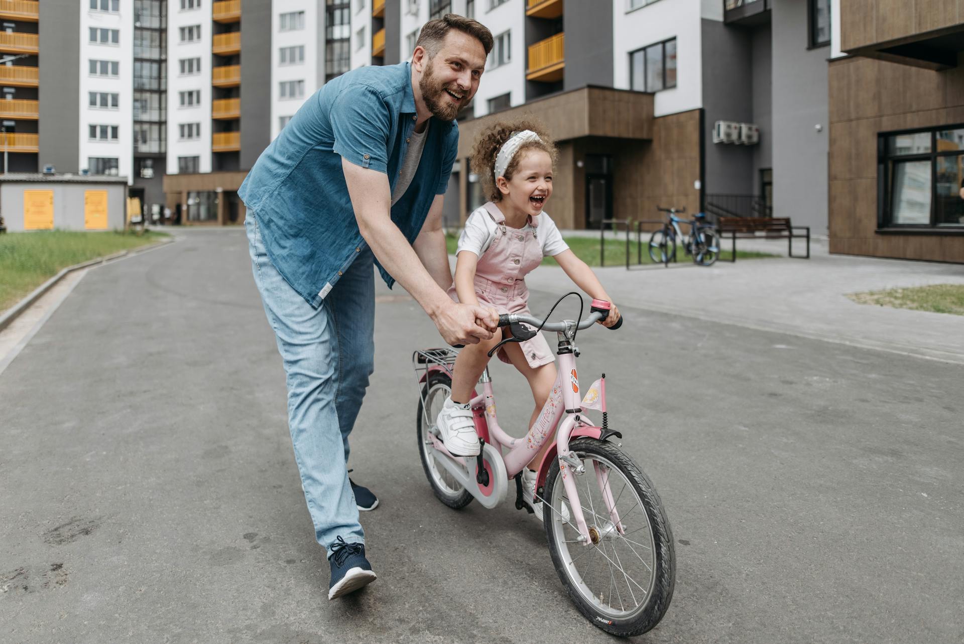 Ein Mann hilft seiner Tochter beim Fahrradfahren | Quelle: Pexels