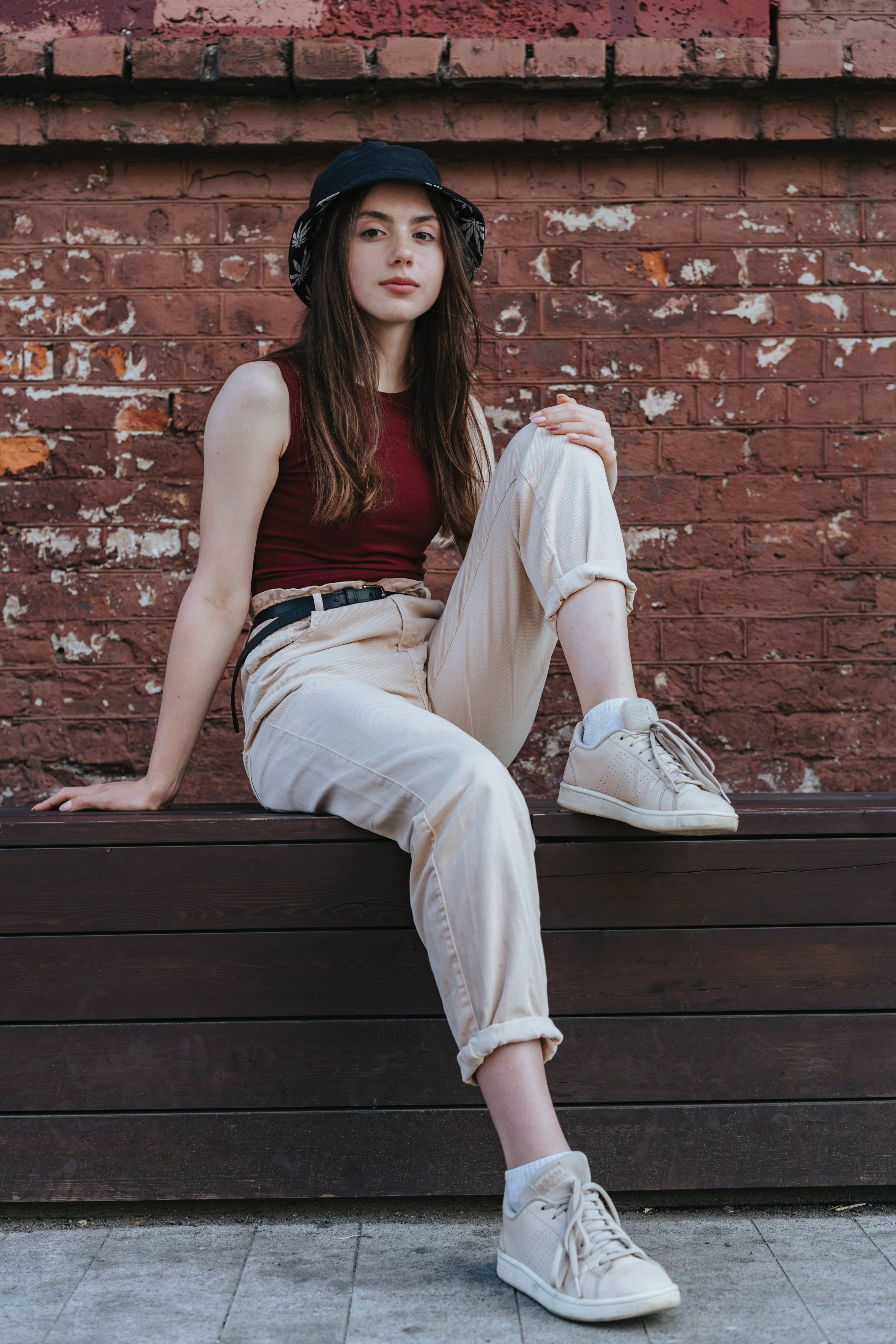 Ein junges Mädchen sitzt auf einer Mauer | Quelle: Pexels