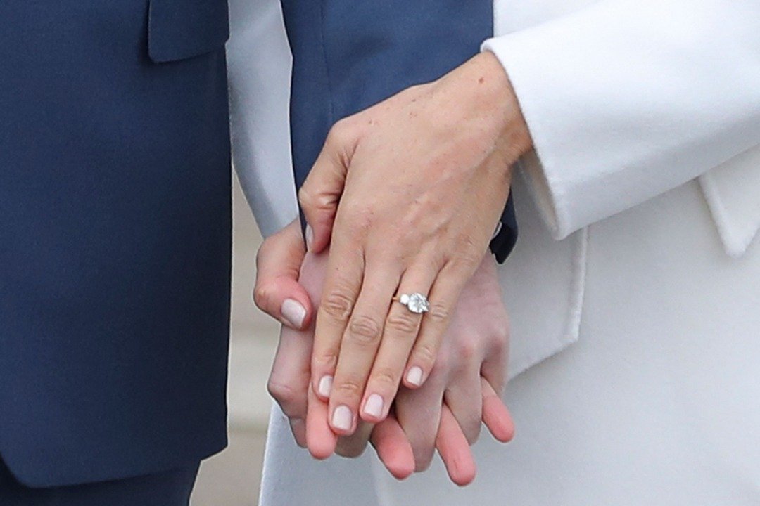 Der britische Prinz Harry steht mit seiner Verlobten US-Schauspielerin Meghan Markle zusammen, während sie ihren Verlobungsring zeigt und sie am 27. November 2017 nach der Bekanntgabe ihrer Verlobung im Sunken Garden des Kensington Palace im Westen Londons für ein Foto posieren. | Quelle: Getty Images