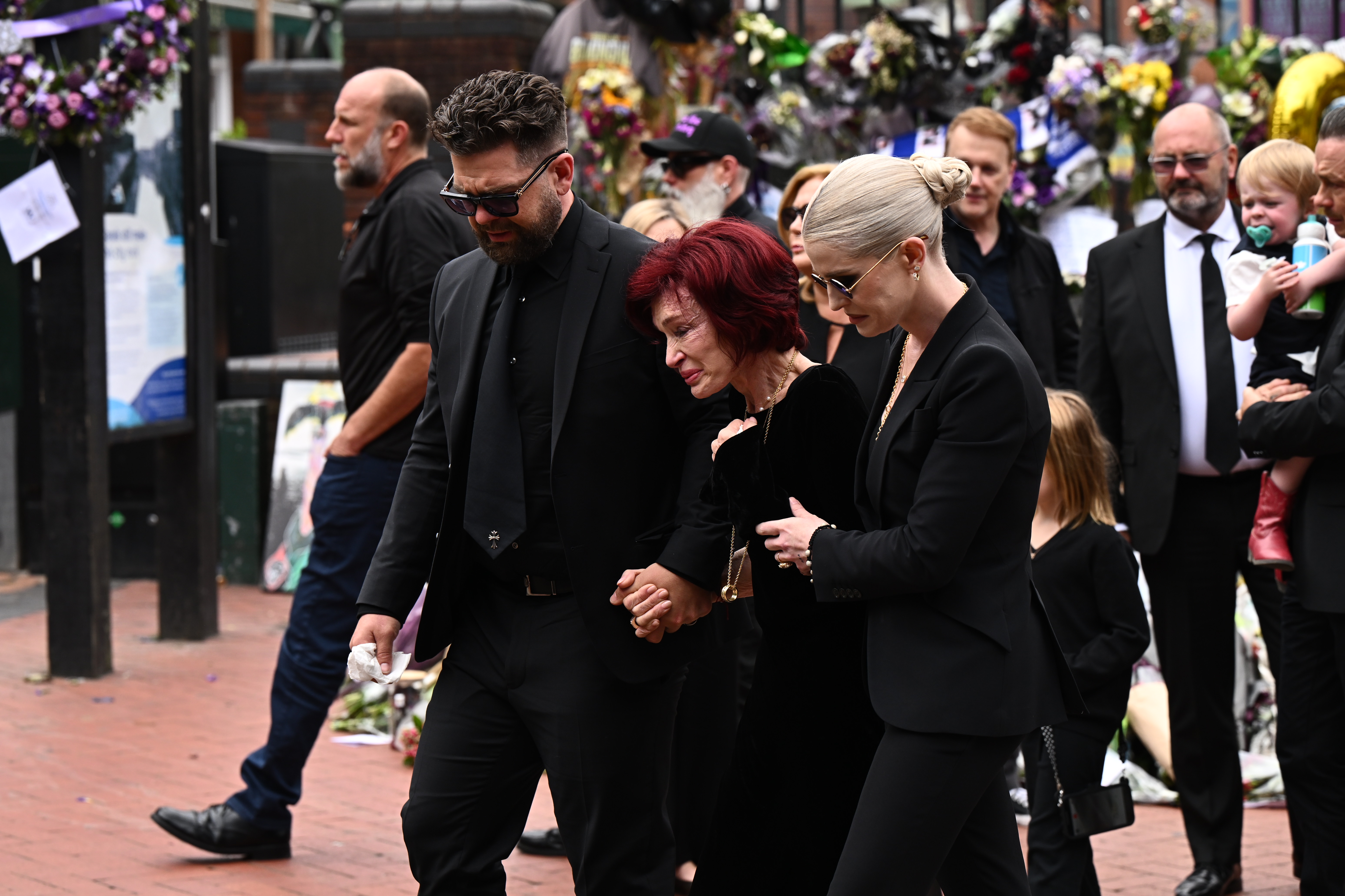 Ozzys Familie sieht sich die Ehrungen der Fans für den verstorbenen Ozzy während seines Trauerzuges in Birmingham am 30. Juli 2025 an | Quelle: Getty Images
