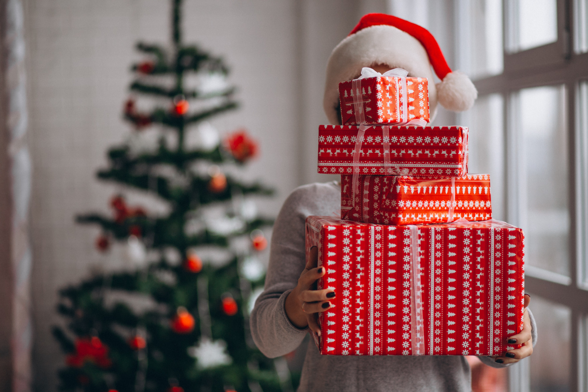 Eine Frau hält einen Stapel Weihnachtsgeschenke | Quelle: Freepik
