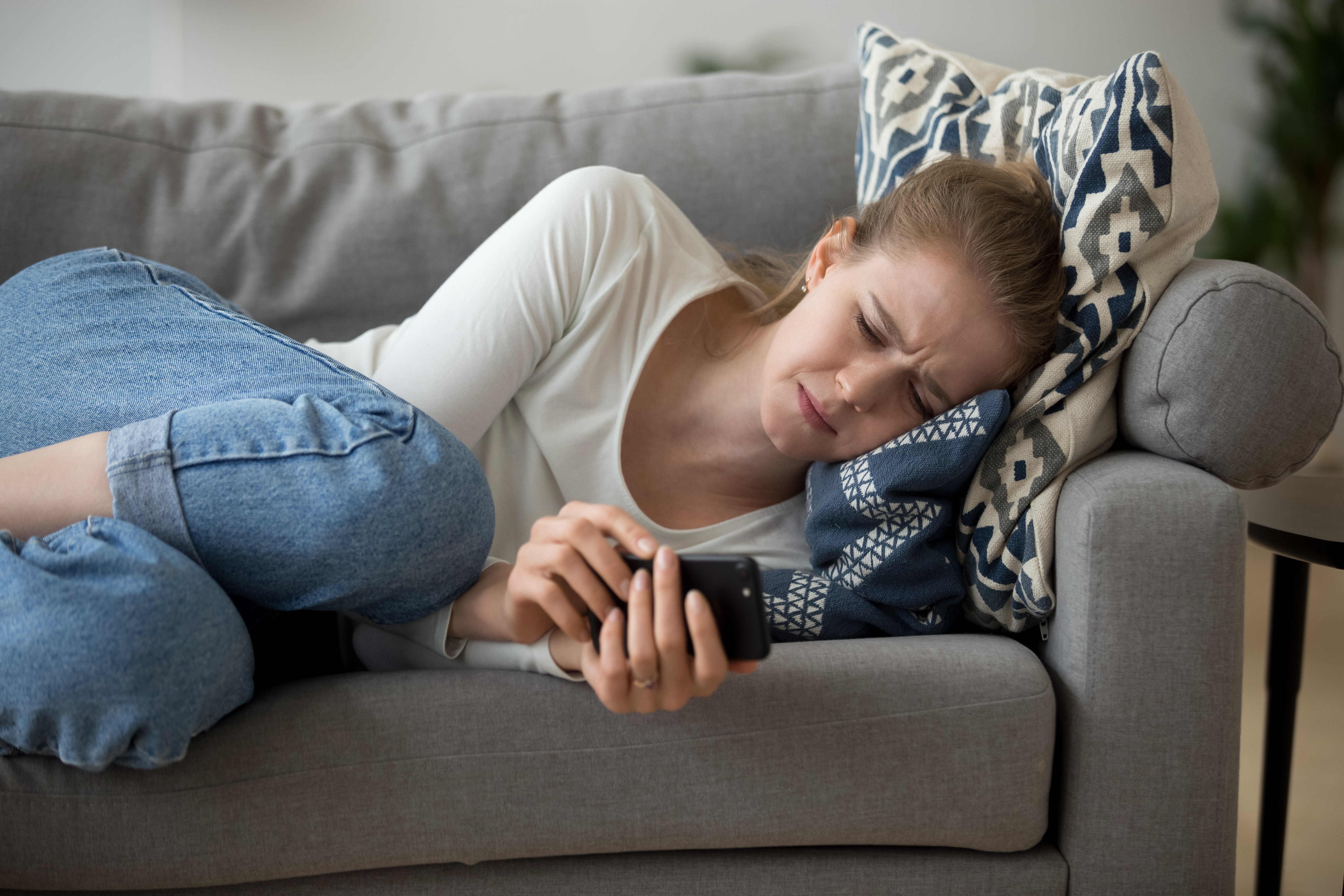 Ein junges Mädchen, das weinend auf der Couch liegt | Quelle: Shutterstock