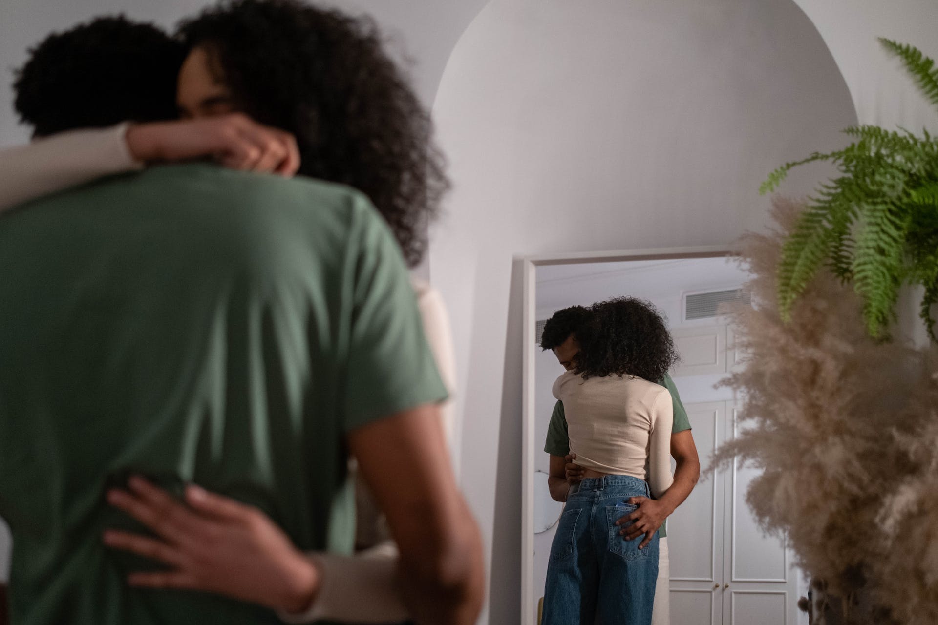 Ein sich umarmendes Paar vor einem Spiegel | Quelle: Pexels