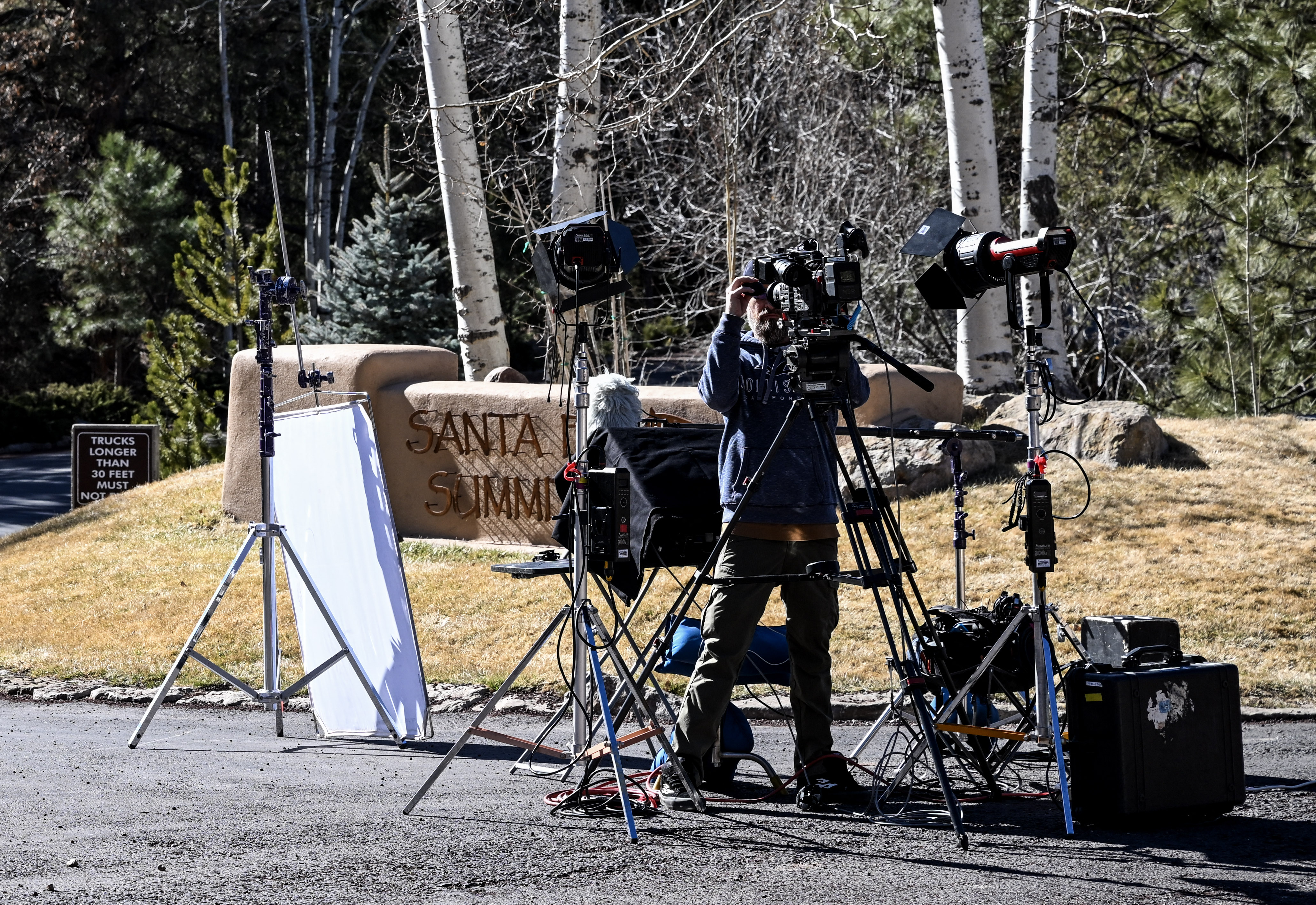 Ein Journalist stellt eine Kamera am Eingang des Viertels Santa Fe Summit auf, in dem der verstorbene Schauspieler Gene Hackman lebte, am 28. Februar 2025 | Quelle: Getty Images