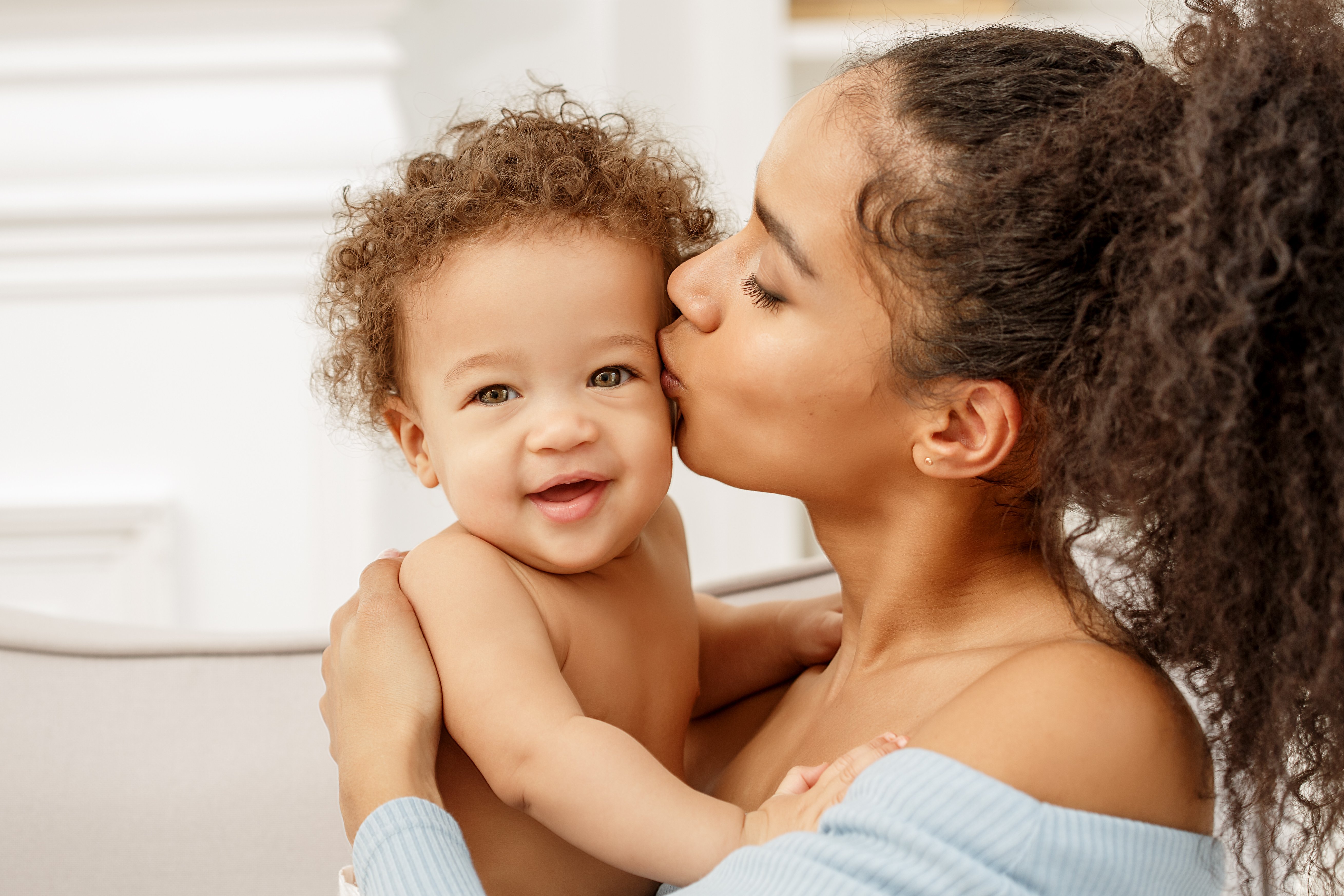 Eine Mutter küsst ihr Baby auf die Wange. | Quelle: Shutterstock
