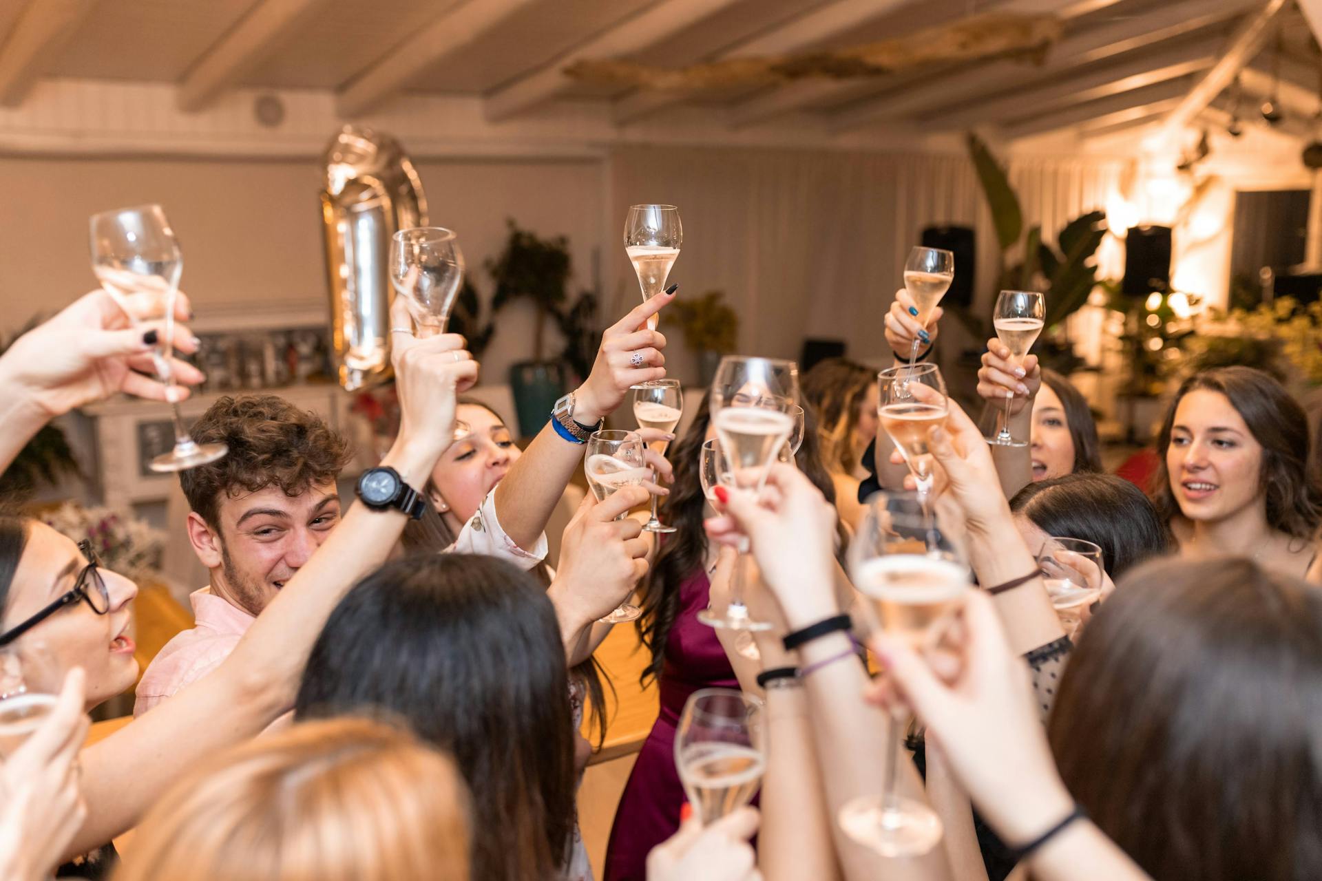 Junge Männer und Frauen erheben ihre Gläser mit Getränken in einem Restaurant | Quelle: Pexels