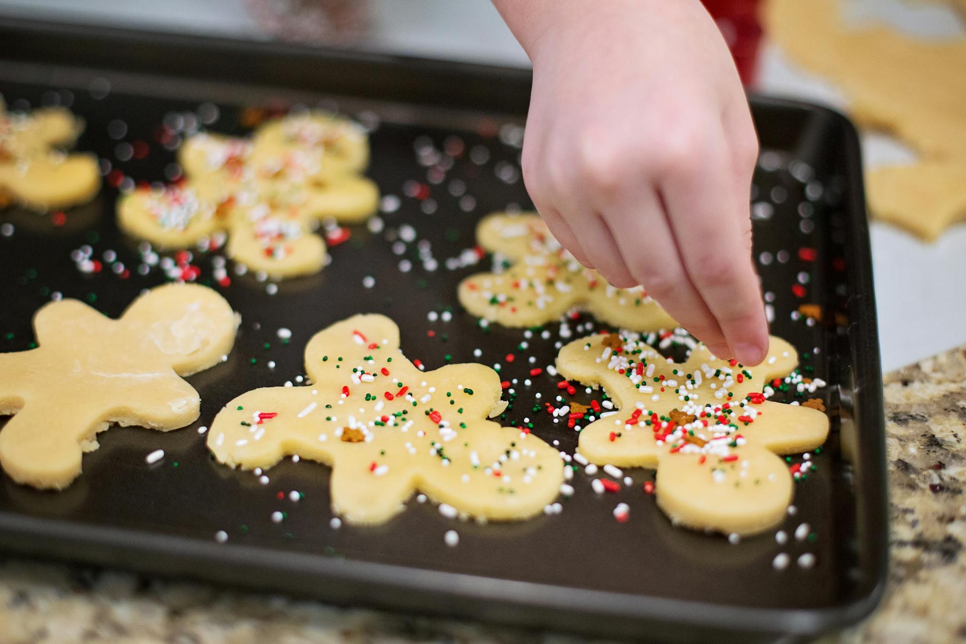 Ein Mädchen, das Lebkuchen mit Streuseln bestreut | Quelle: Pexels