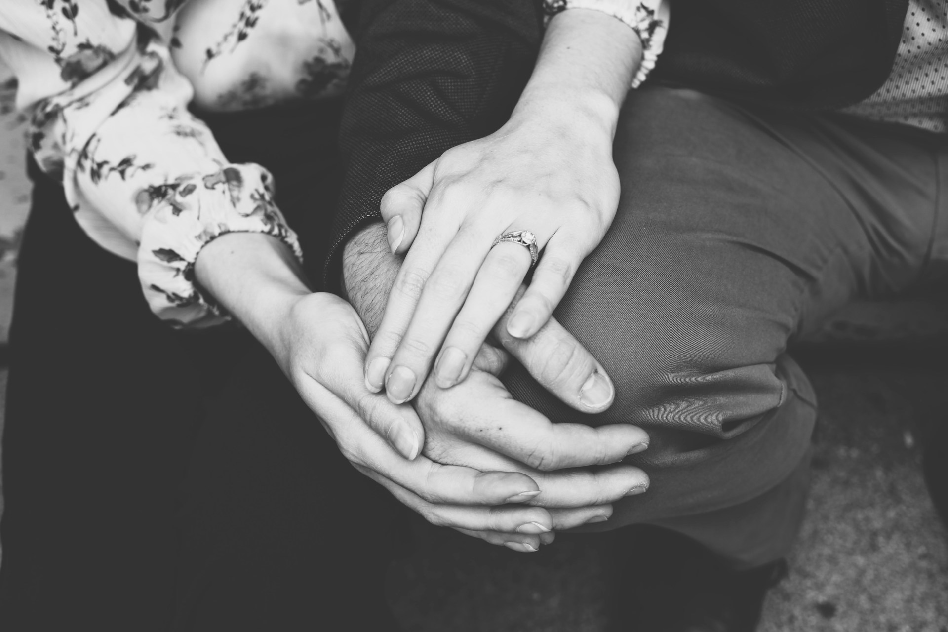 Graustufenaufnahme eines händchenhaltenden Paares | Quelle: Unsplash