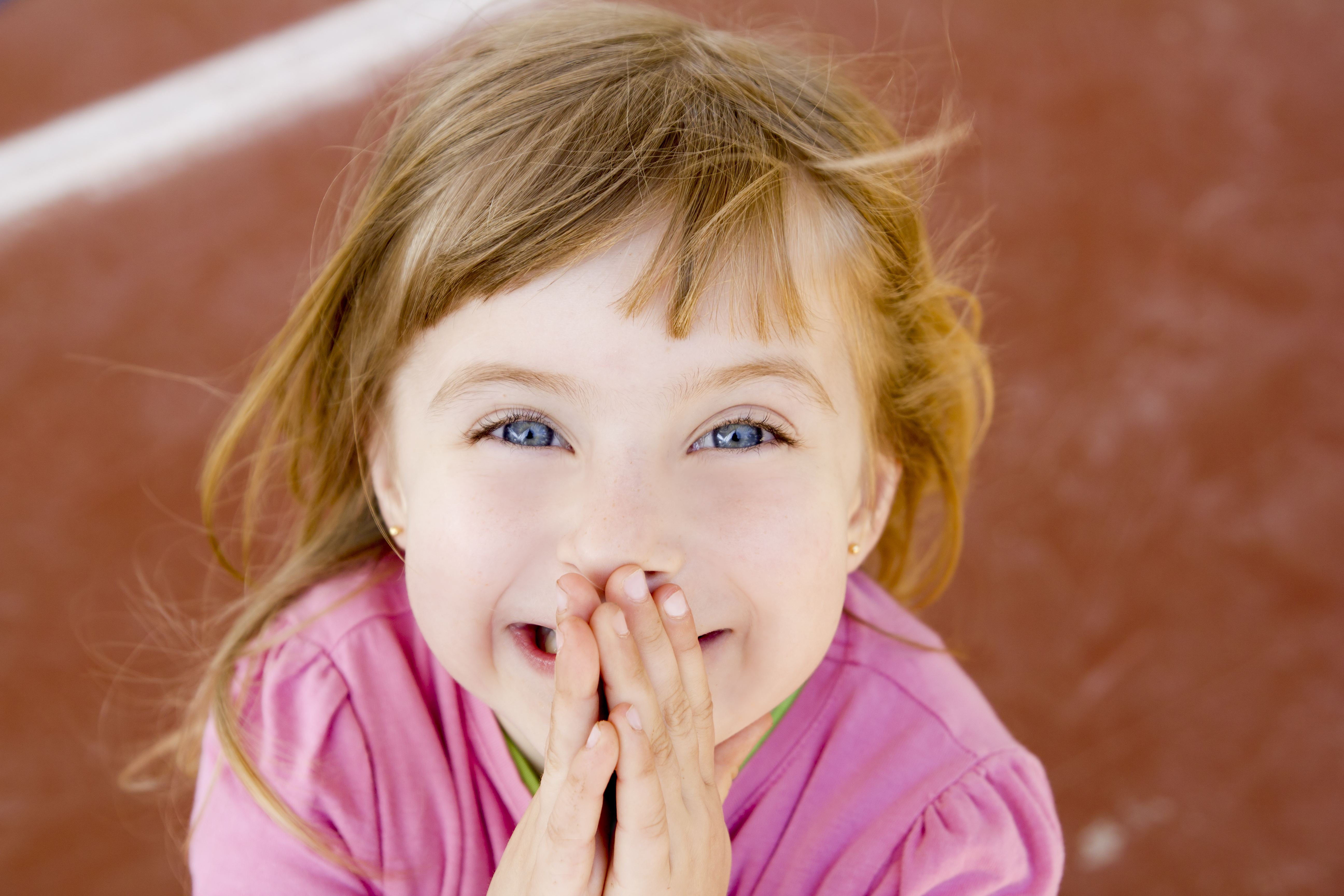Blondes fröhlich lächelndes kleines Mädchen lacht aufgeregt | Quelle: Getty Images