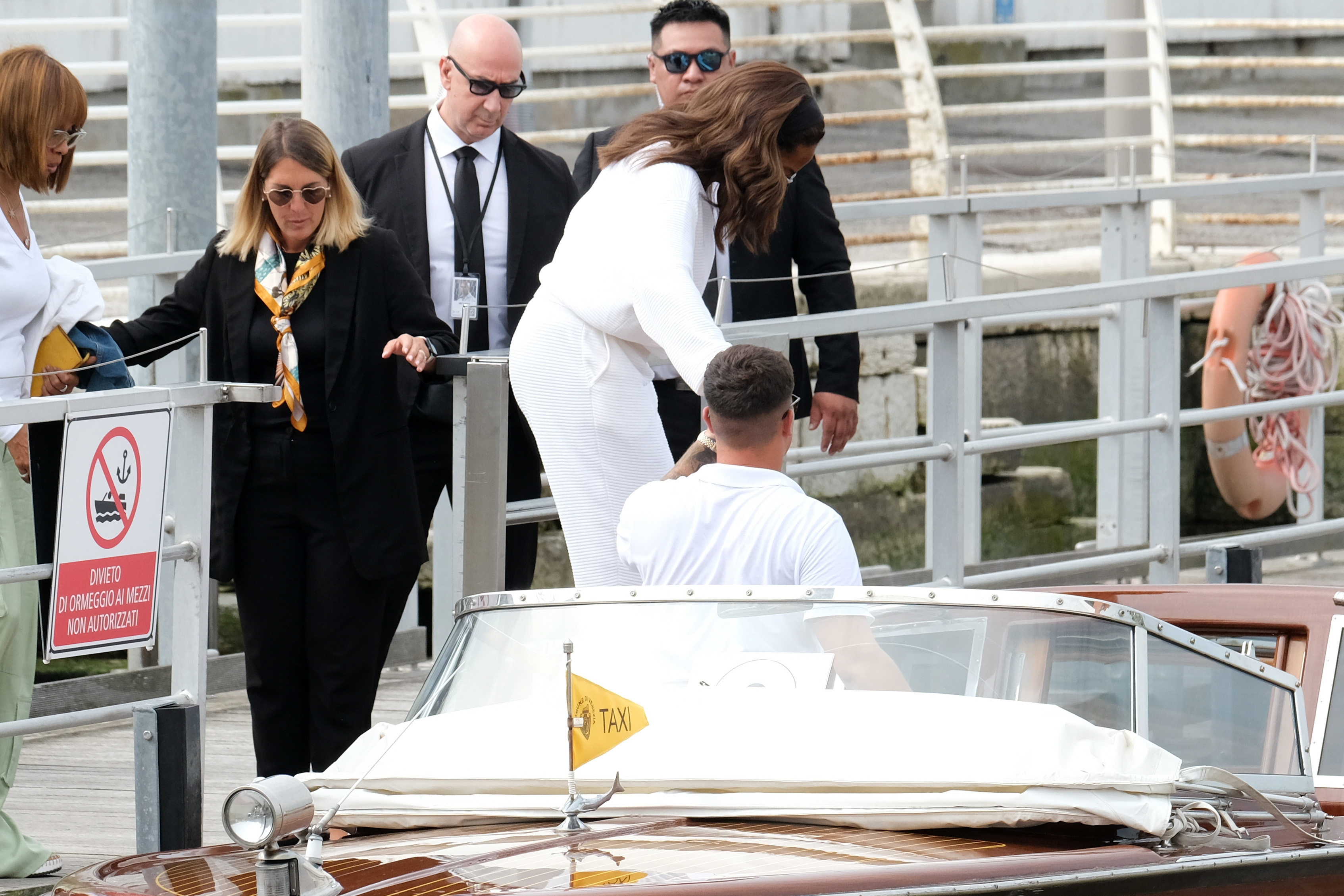 Oprah Winfrey ist auf dem Marco Polo Flughafen in Venedig. Sie steigt mit Hilfe des Taxibootführers in das Taxiboot ein.