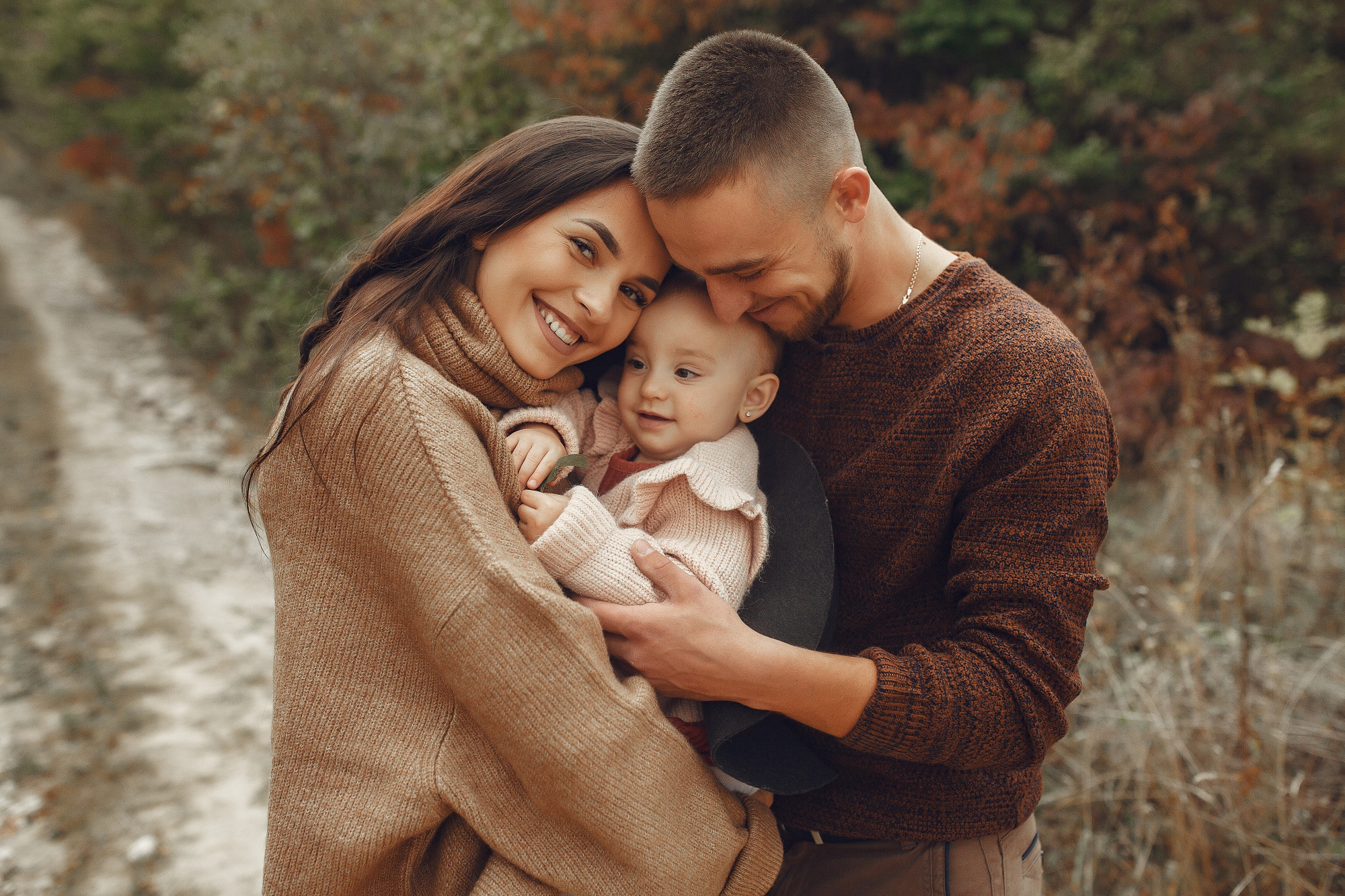 Eine glückliche dreiköpfige Familie, die es sich draußen gemütlich gemacht hat | Quelle: Freepik