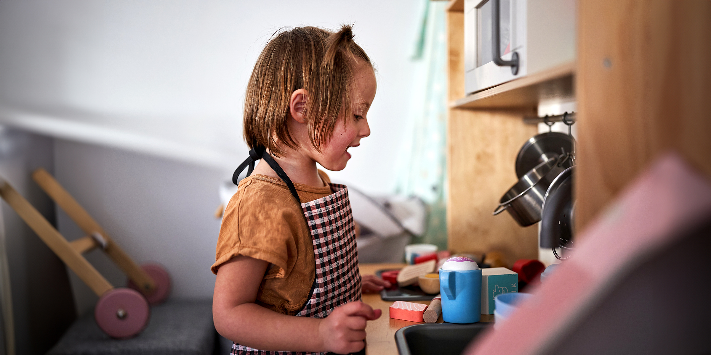 Ein kleines Mädchen spielt mit ihrem Mini-Küchen-Set | Quelle: Shutterstock