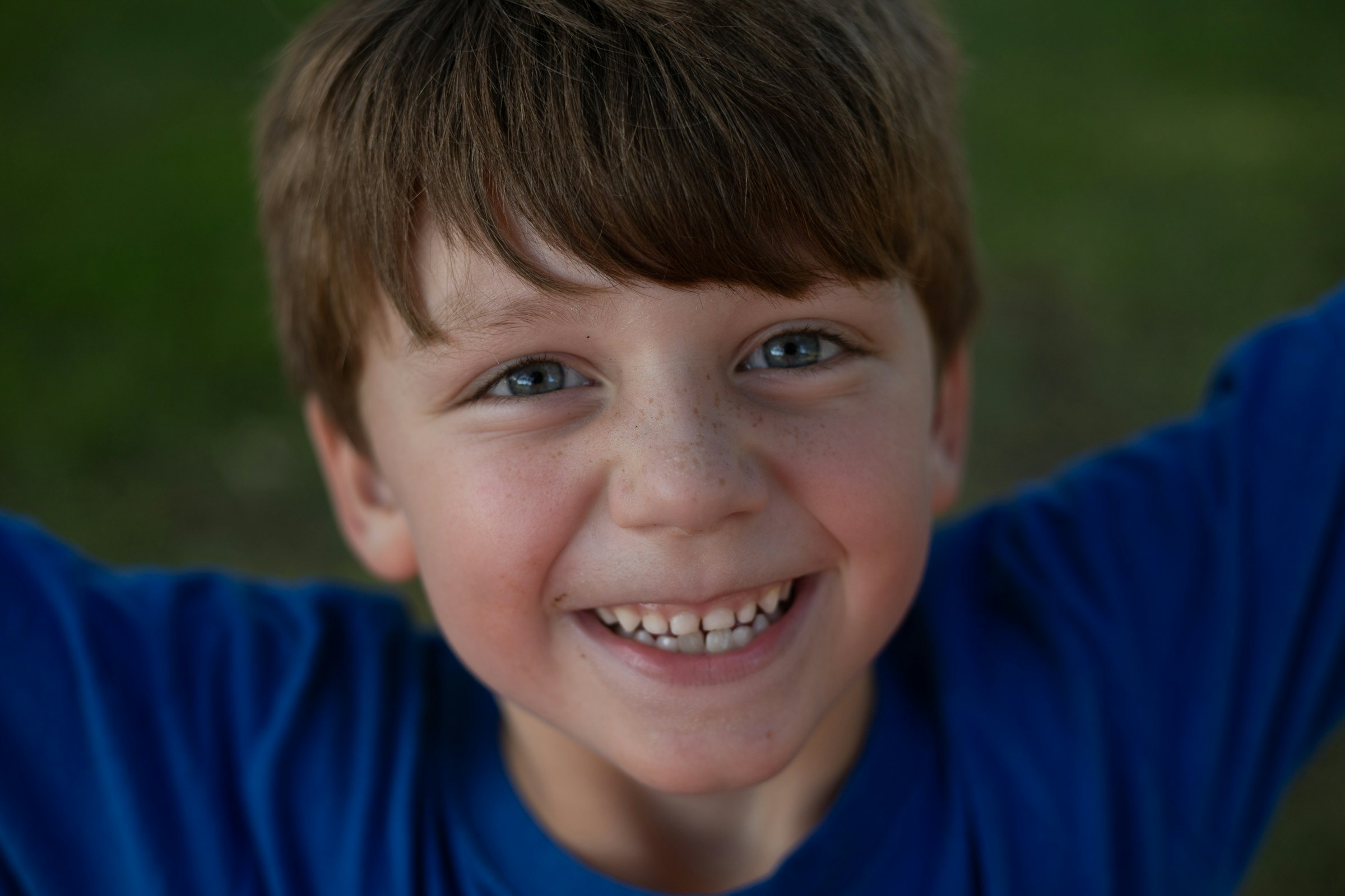Ein lächelnder kleiner Junge in einem blauen Hemd | Quelle: Unsplash