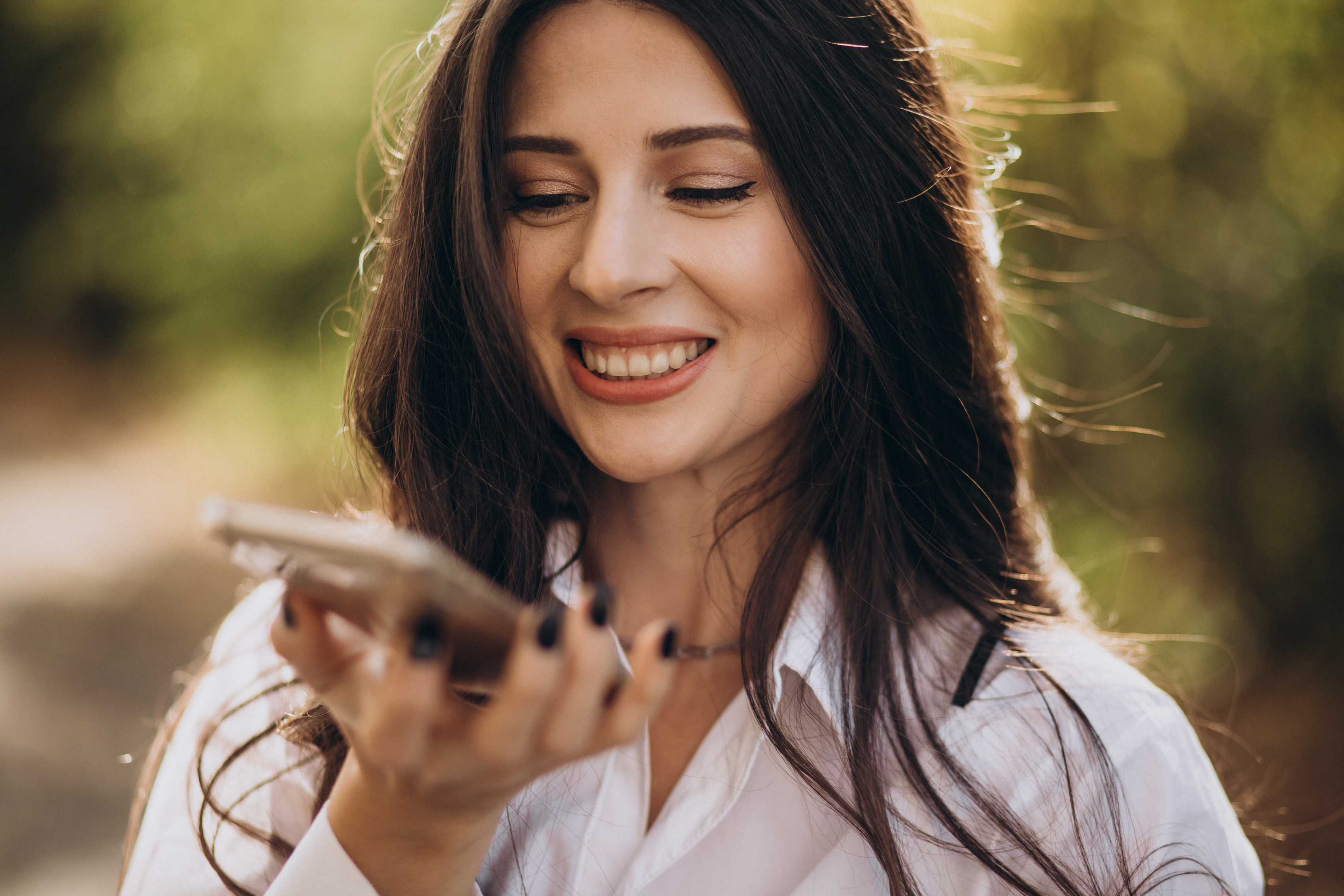 Eine lächelnde Frau, die mit ihrem Telefon spricht | Quelle: Freepik