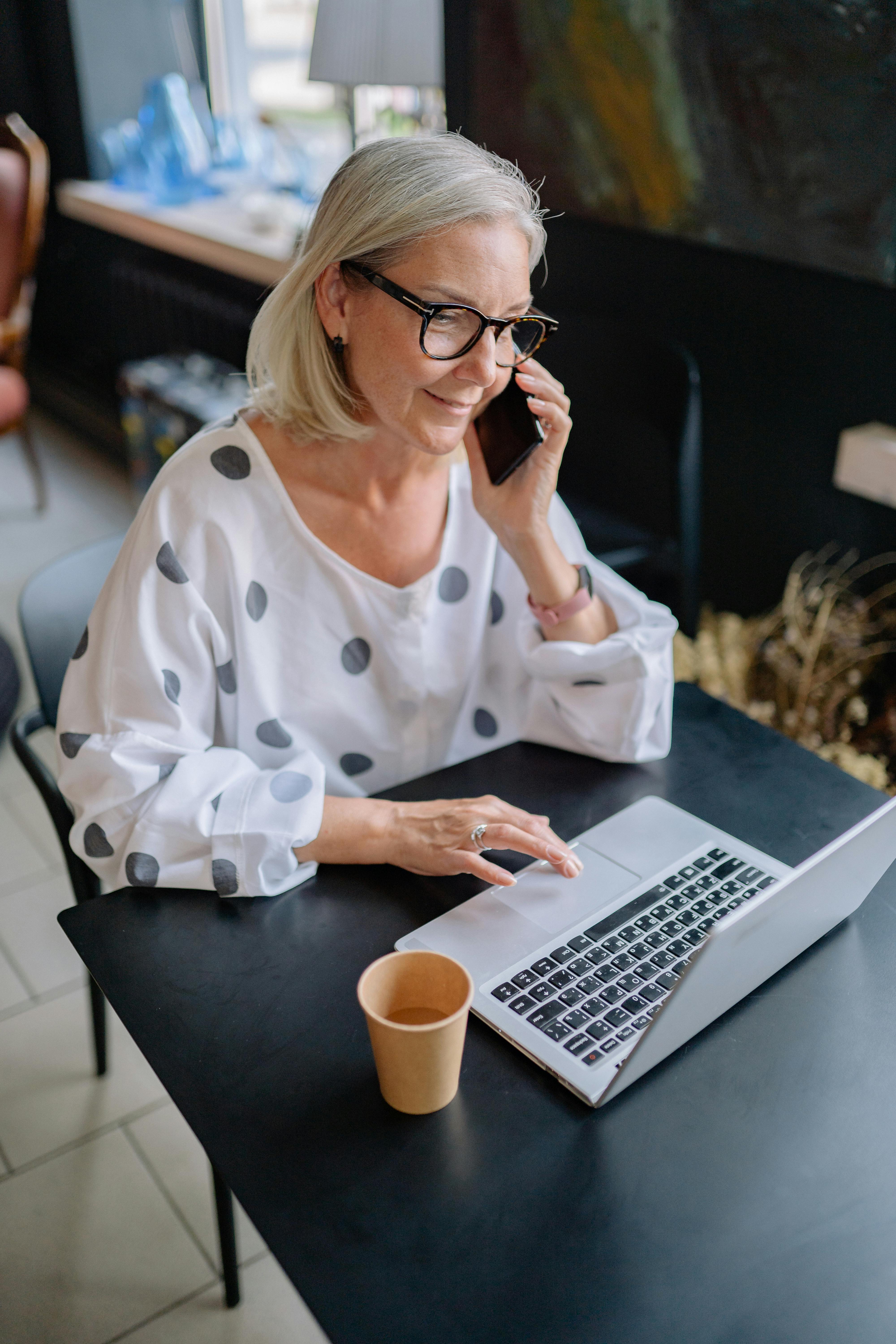 Eine Frau benutzt ihr Telefon und ihren Laptop gleichzeitig | Quelle: Pexels