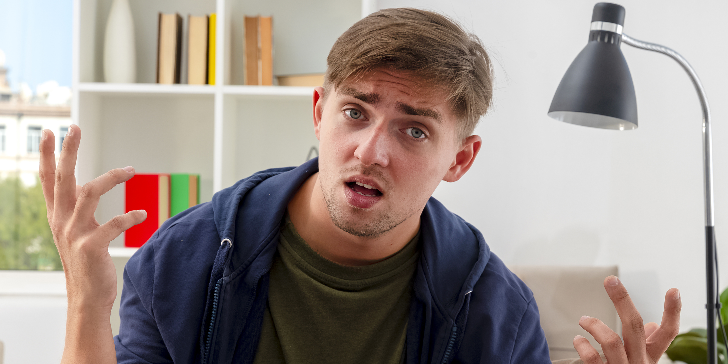 Ein verwirrter und frustrierter junger Mann sitzt in einem Haus | Quelle: Freepik/stockking