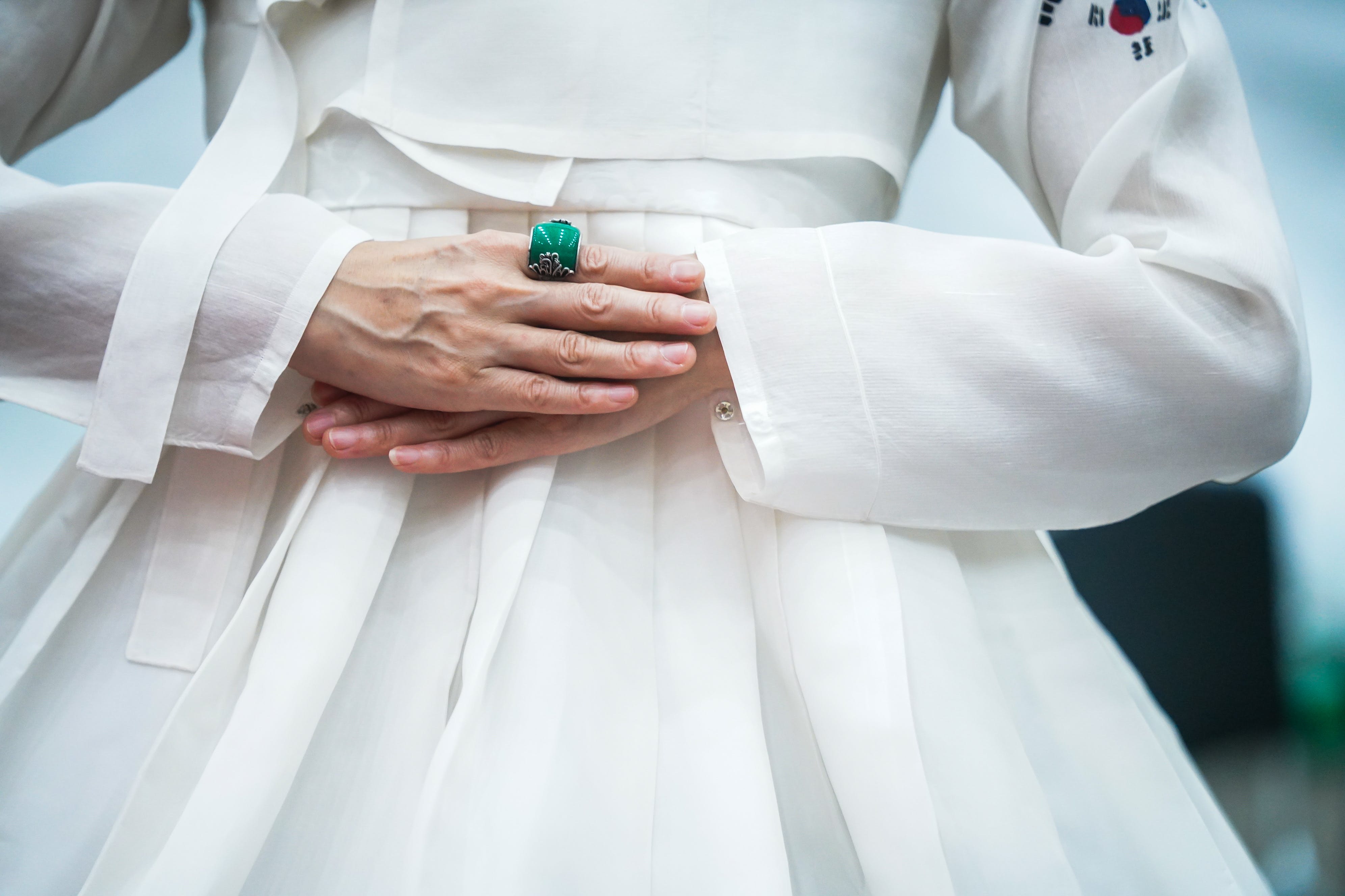 Eine Frau in einem weißen Hanok trägt einen Smaragdring | Quelle: Pexels