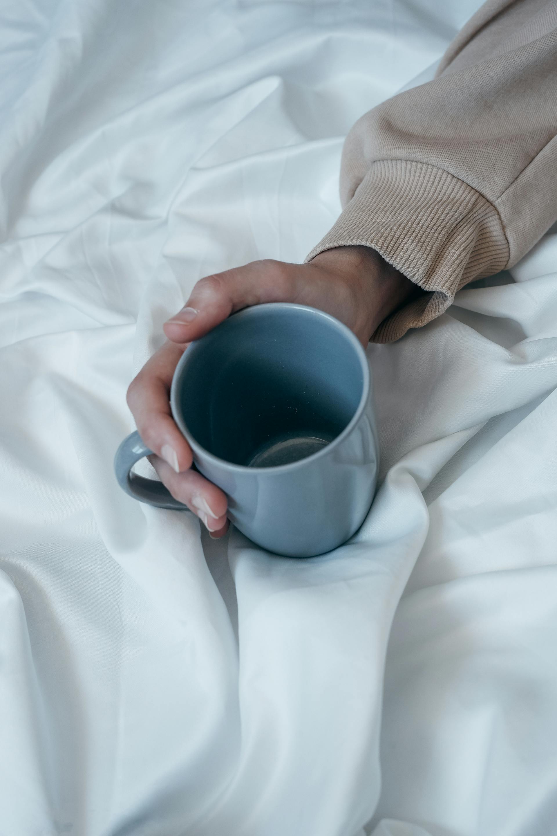Ein Mann hält einen Kaffeebecher | Quelle: Pexels