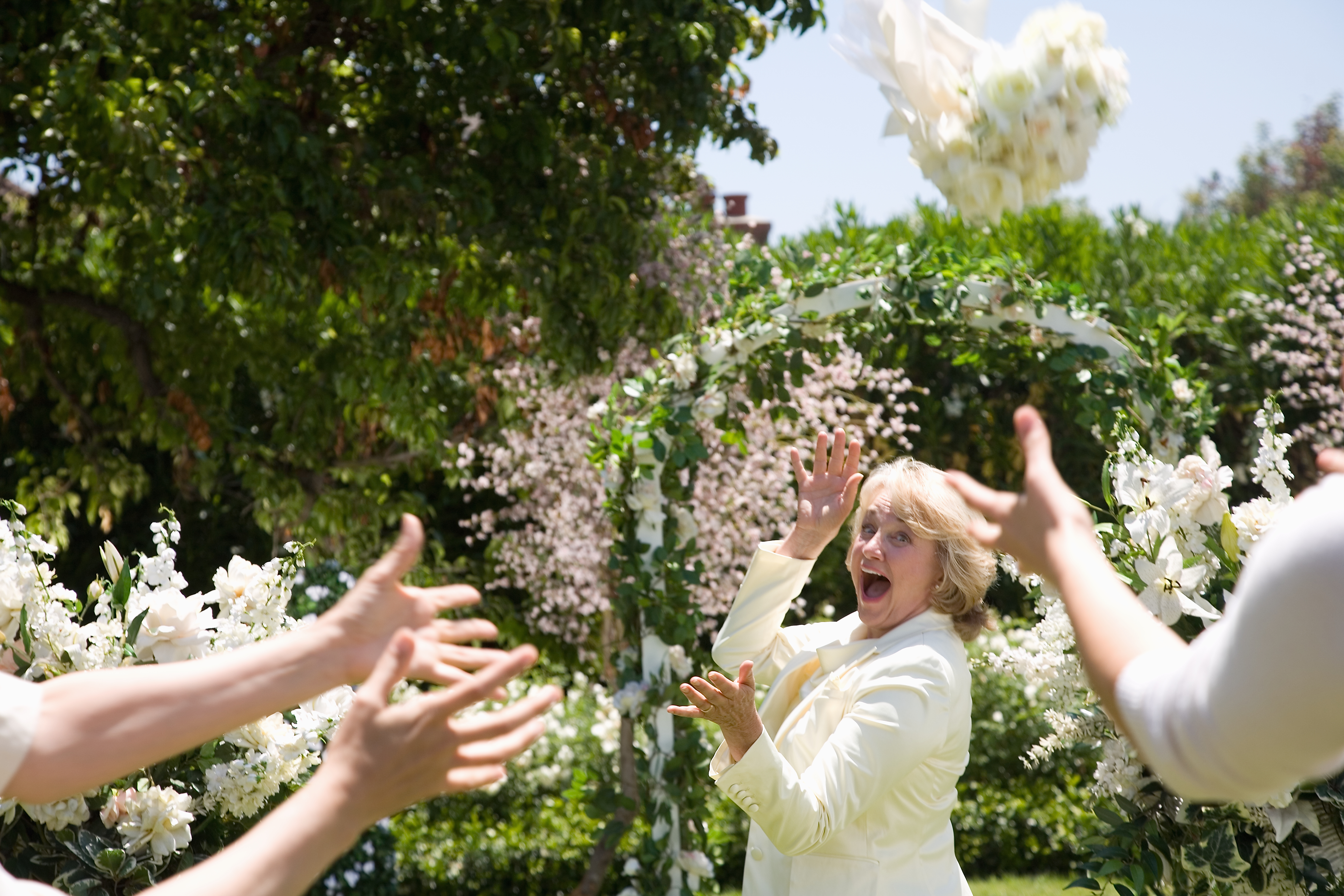 Braut wirft Blumenstrauß, lachend | Quelle: Getty Images