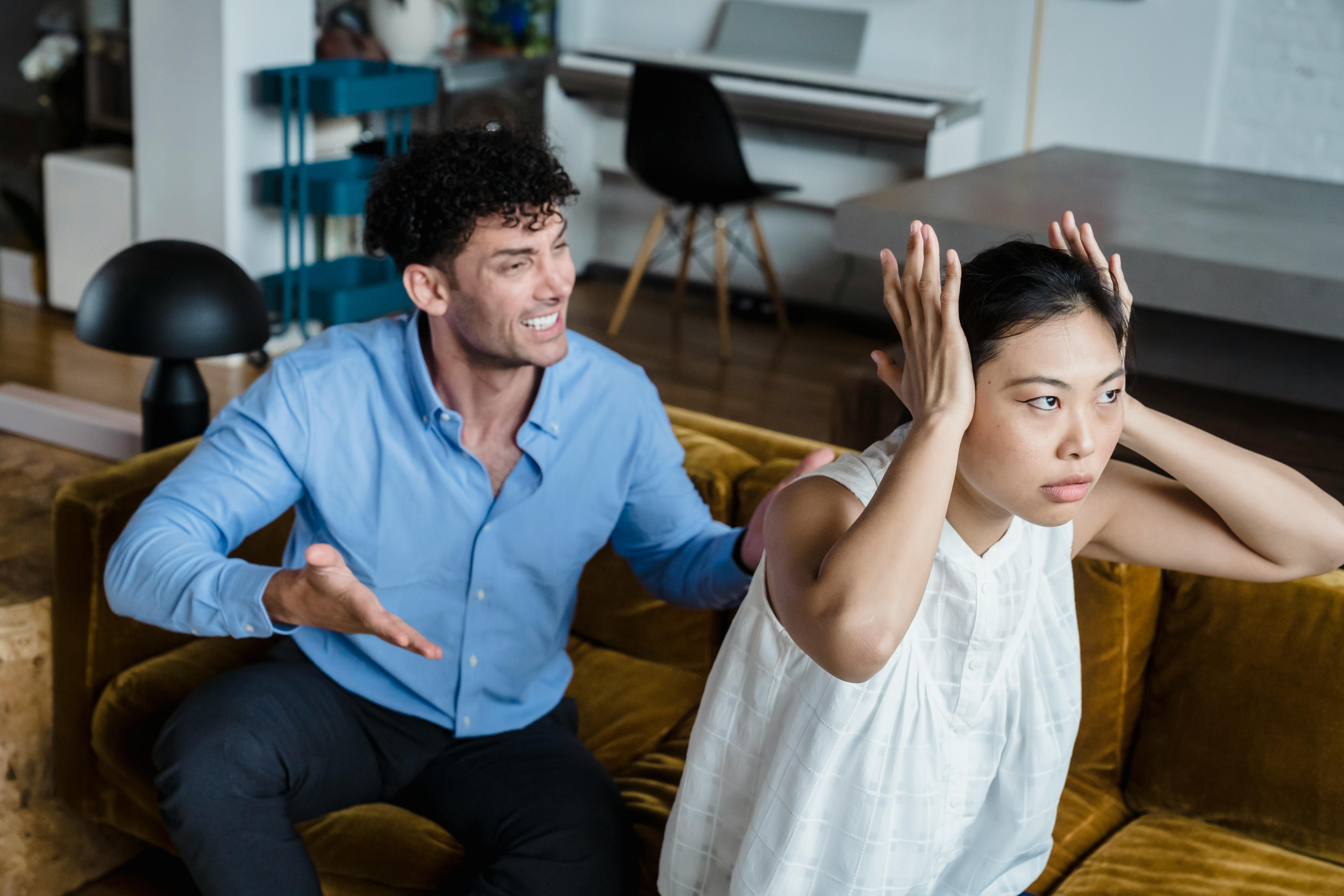 Ein streitendes Paar, das auf einer Couch sitzt | Quelle: Pexels