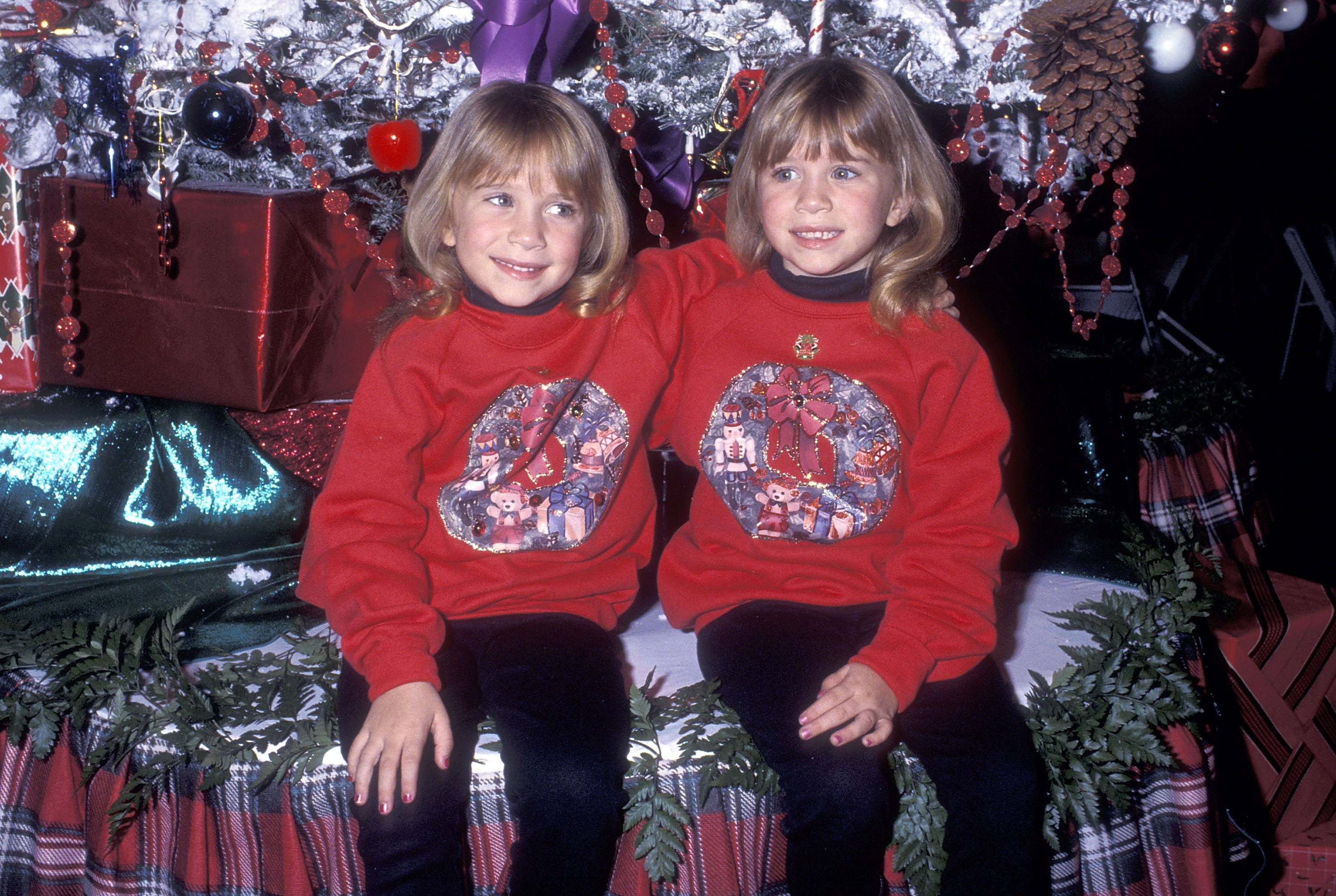 Fröhliches, breites Grinsen und die passenden, rund geschnittenen blonden Bobs ließen die Schwestern im Alter von 6 Jahren bei der Weihnachtsparade am 29. November 1992 besonders hervorstechen. Dort zeugten ihre festlichen, leuchtend roten Sweatshirts mit aufgestickten Kränzen und Teddybären, die sie über schwarzen Rollkragenpullovern trugen, von einer zunehmend lebhaften Bühnenpräsenz.