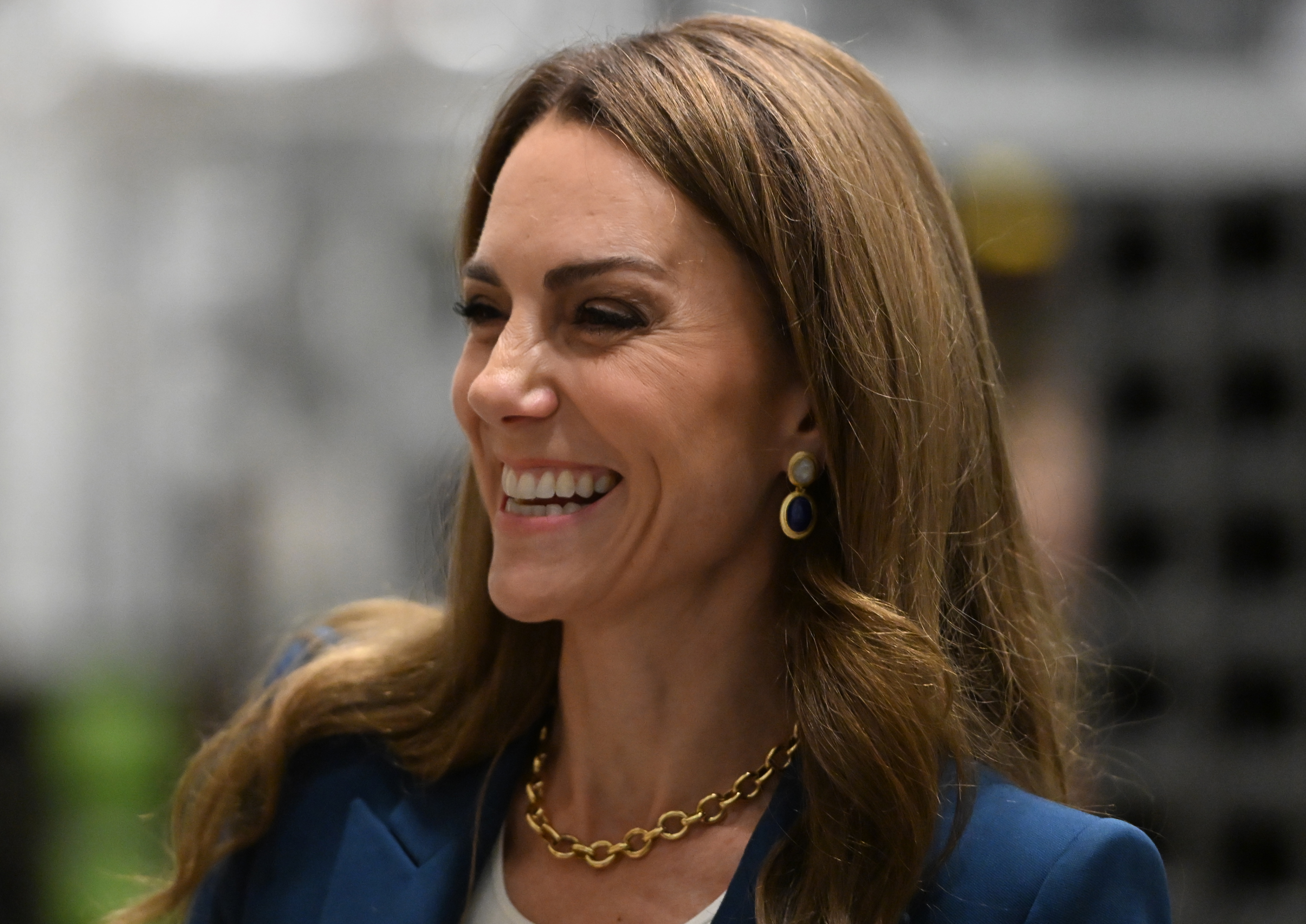 Prinzessin Catherine lächelt während ihres Museumsbesuchs am 10. Juni 2025. Sie trägt einen königsblauen Blazer, eine auffällige Goldkette und blaue Tropfenohrringe. Ihre sanften Wellen und ihr natürliches Make-up ergänzen ihr selbstbewusstes und gepflegtes Auftreten.