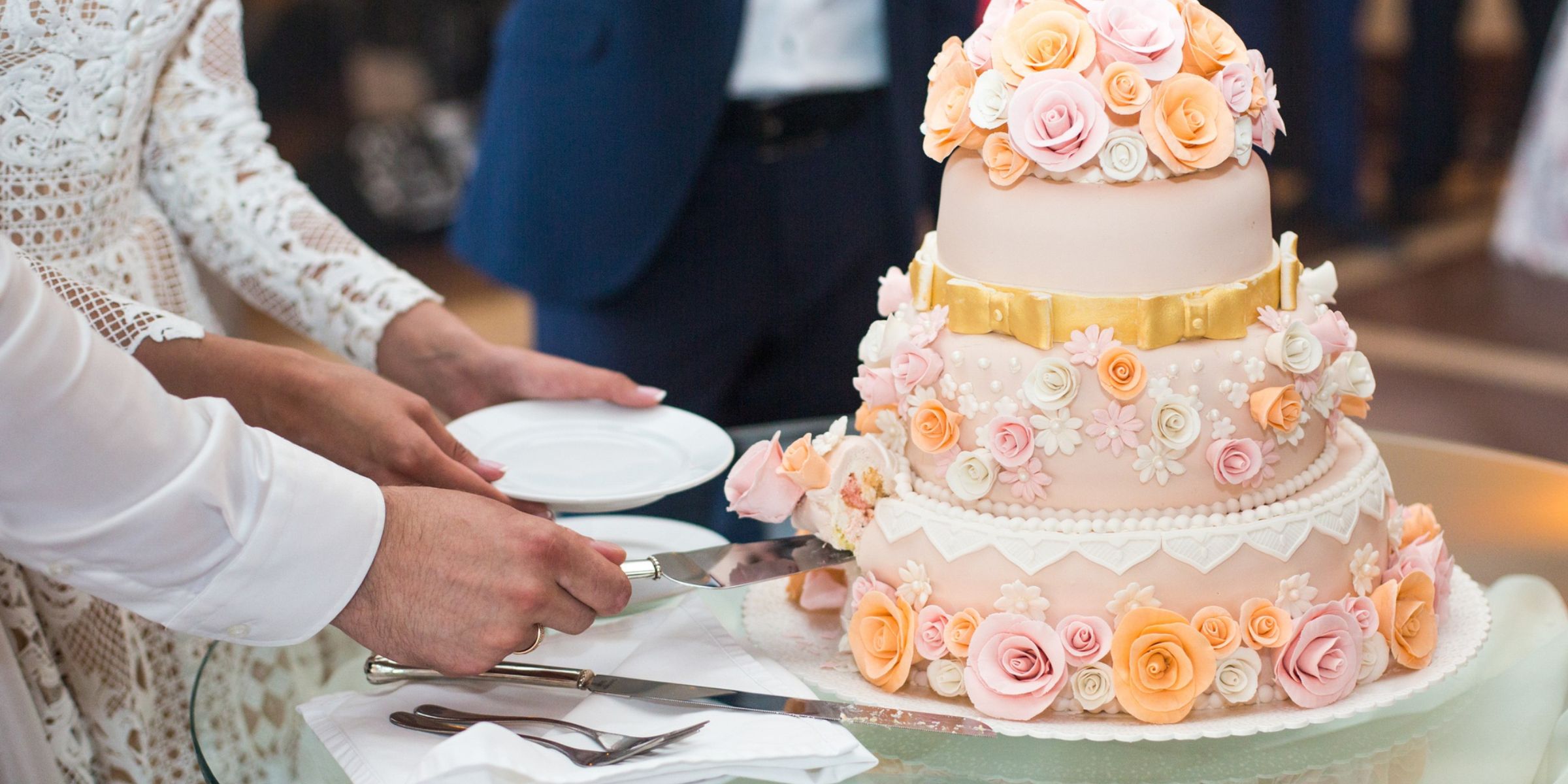 Ein Brautpaar beim Anschneiden der Hochzeitstorte | Quelle: Magnific