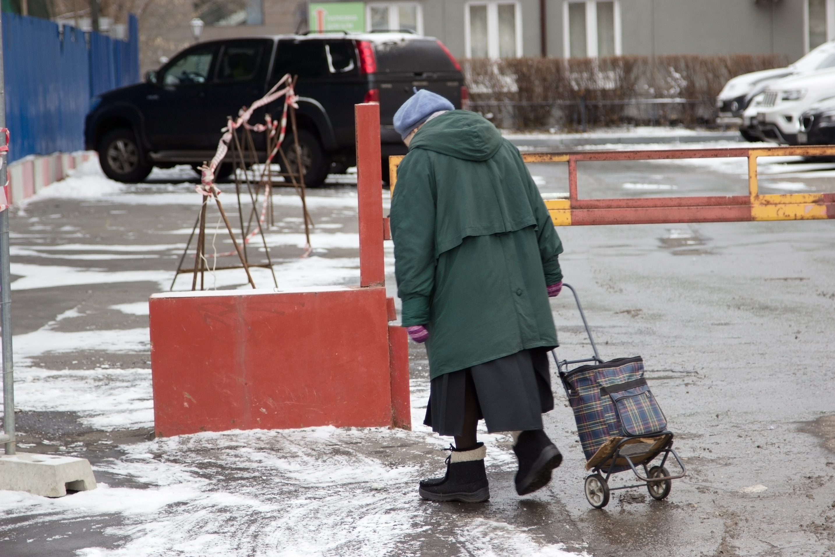 Einsame ältere Dame auf einer verschneiten Straße | Quelle: Shutterstock
