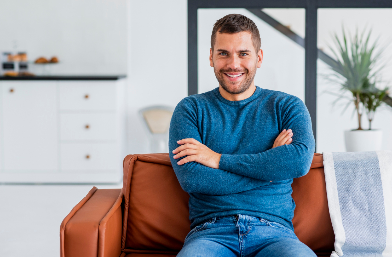 Ein lächelnder Mann sitzt auf der Couch | Quelle: Freepik