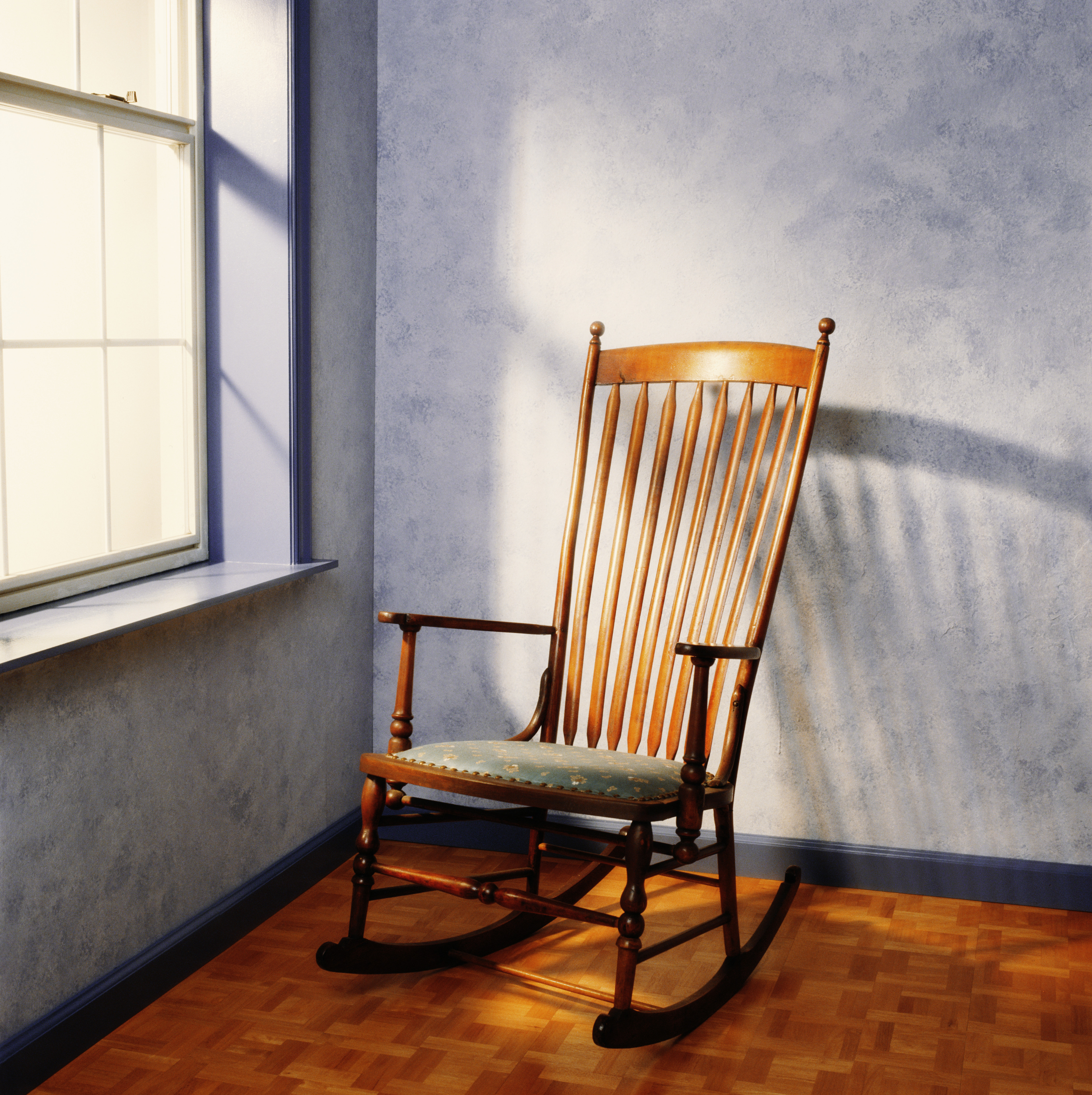 Ein leerer Schaukelstuhl in der Nähe eines Fensters | Quelle: Getty Images