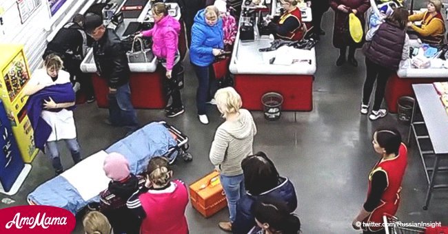 Eine Frau gebärt auf dem Fußboden eines Supermarkts, während die anderen so tun, als ob nichts passiert wäre