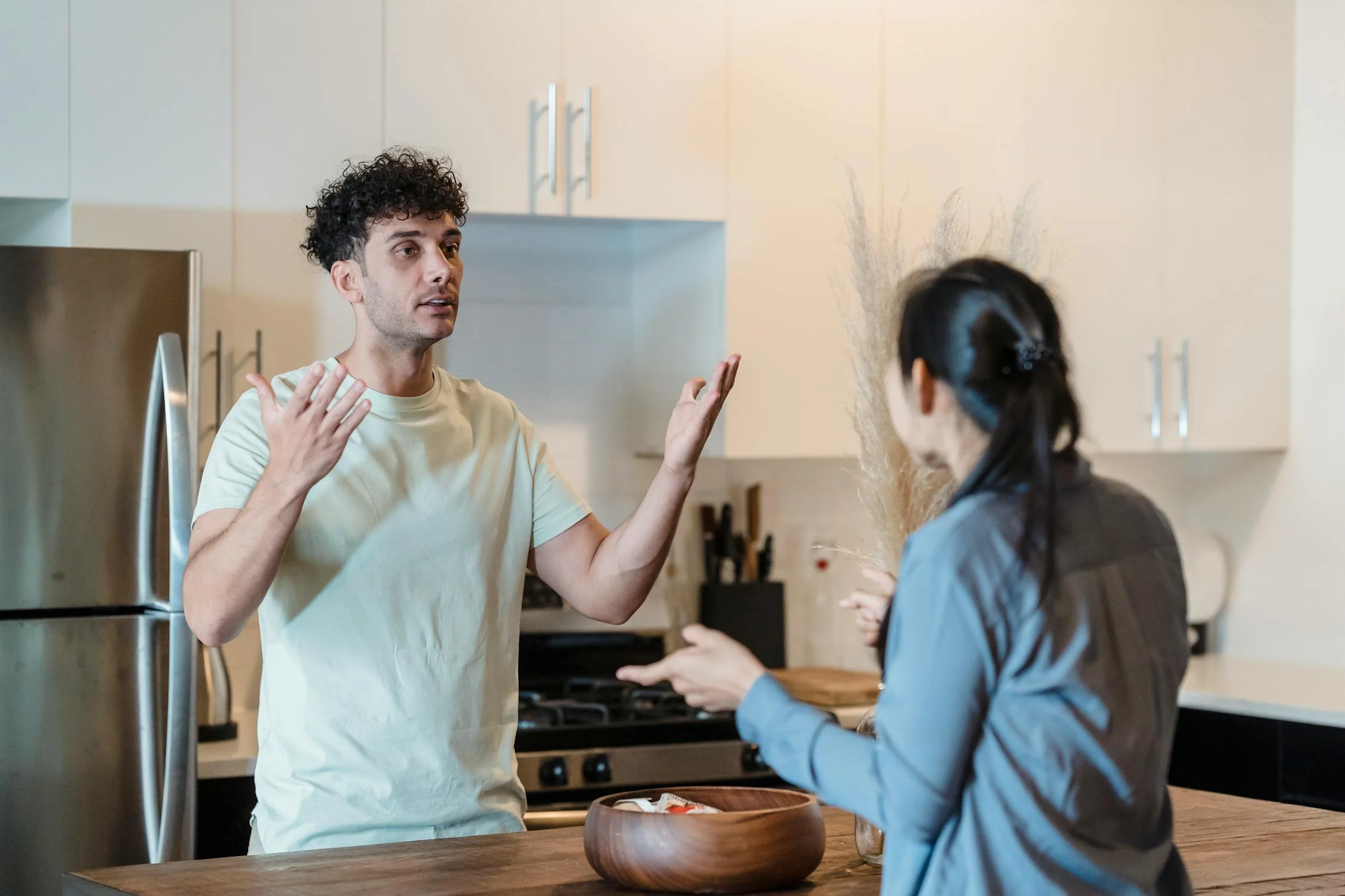 Ein Mann im Gespräch mit seiner Frau in seiner Küche | Quelle: Pexels