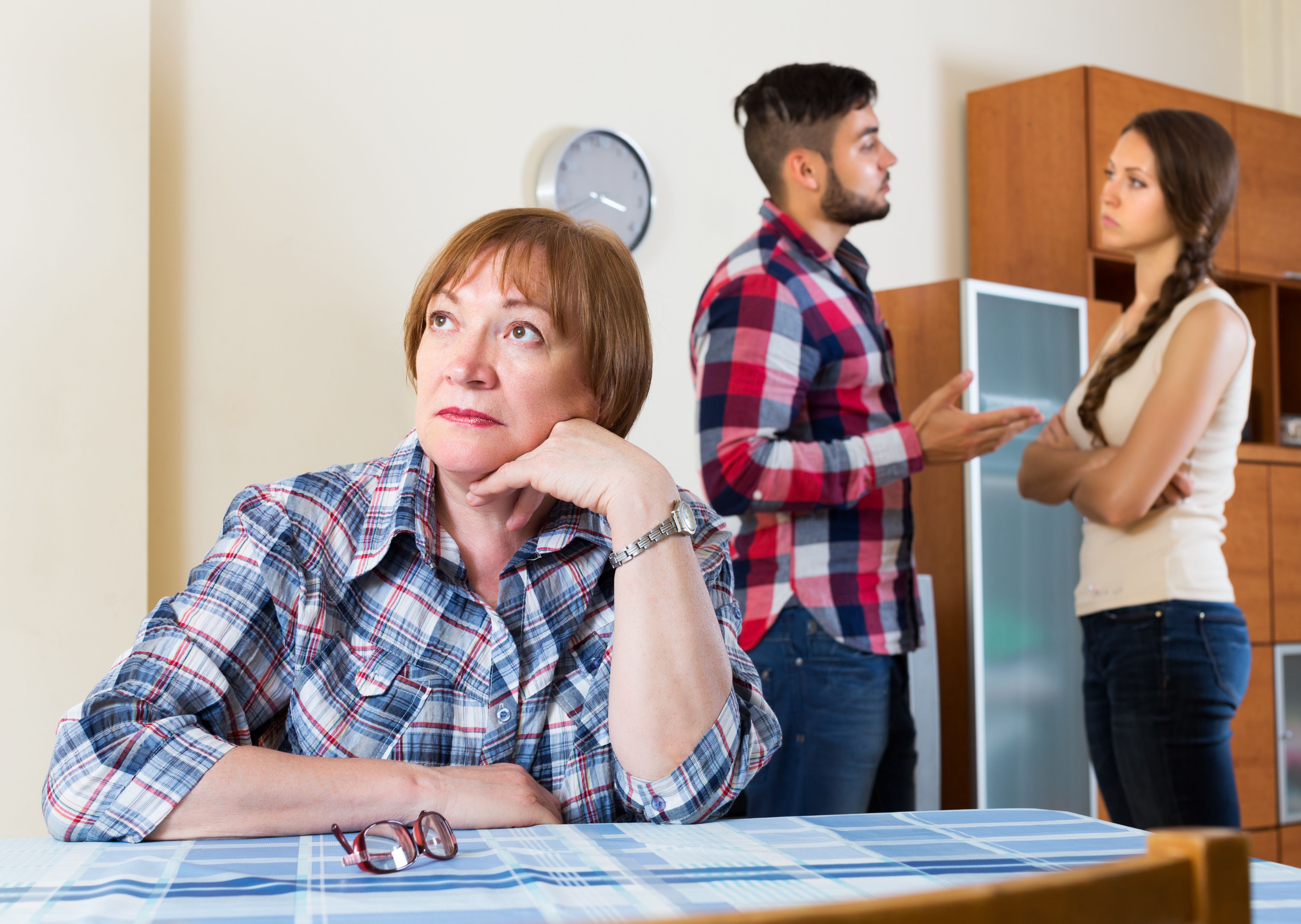 Eine Frau auf dem Tisch, während sich zwei Leute hinter ihr unterhalten. | Quelle: Getty Images