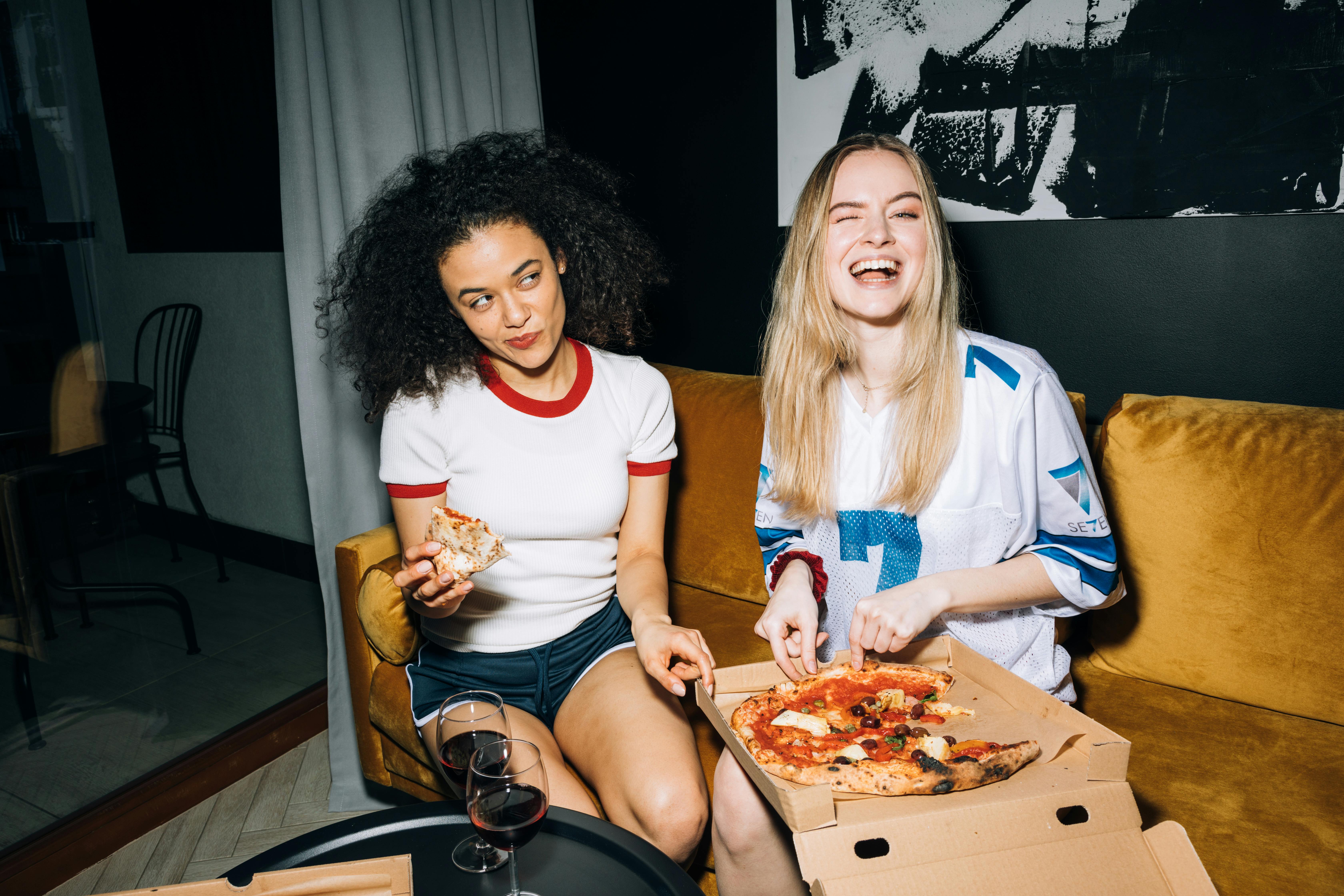 Zwei Frauen beim Pizzaessen | Quelle: Pexels