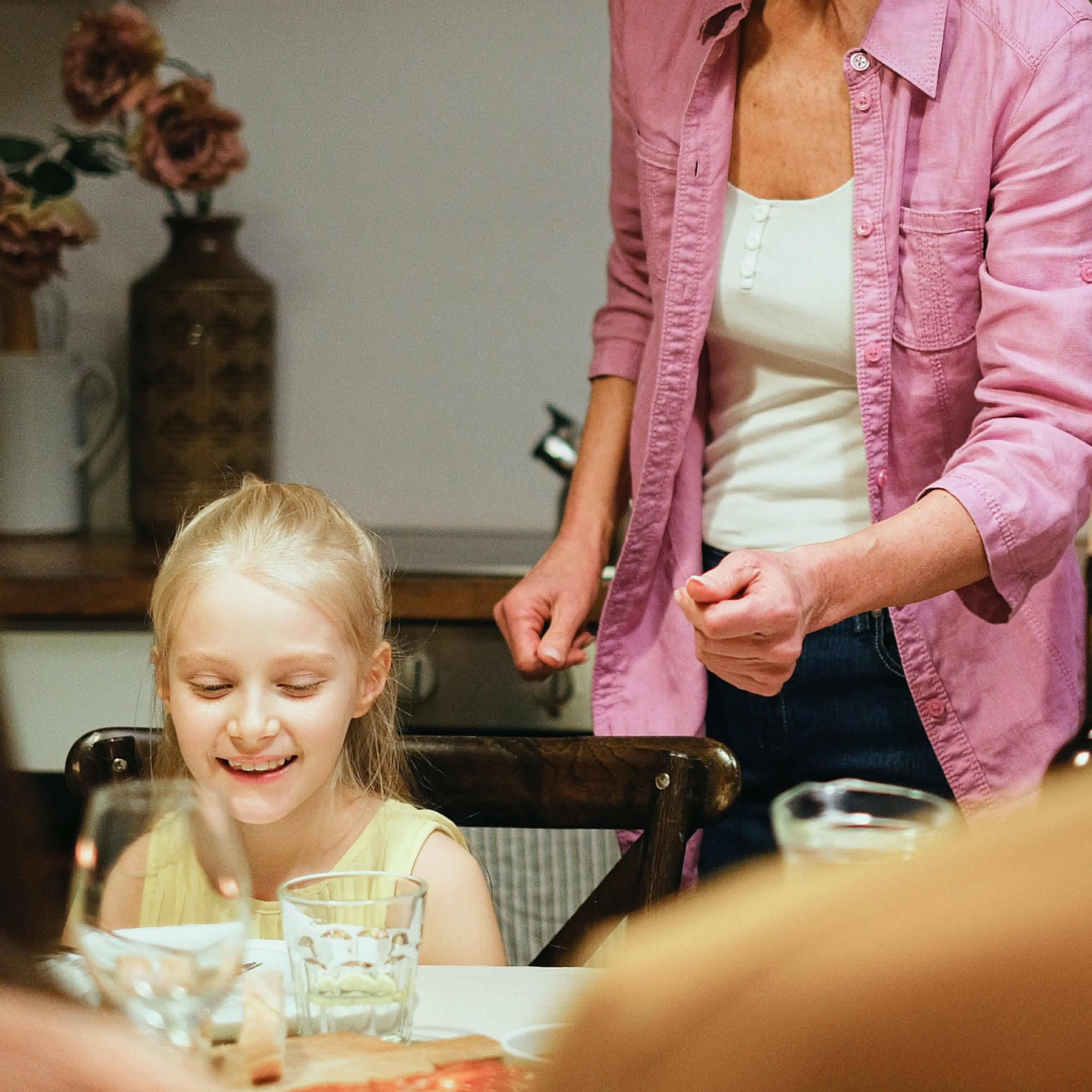 Eine Frau deckt das Abendessen für die Kinder an einem Tisch | Quelle: Pexels