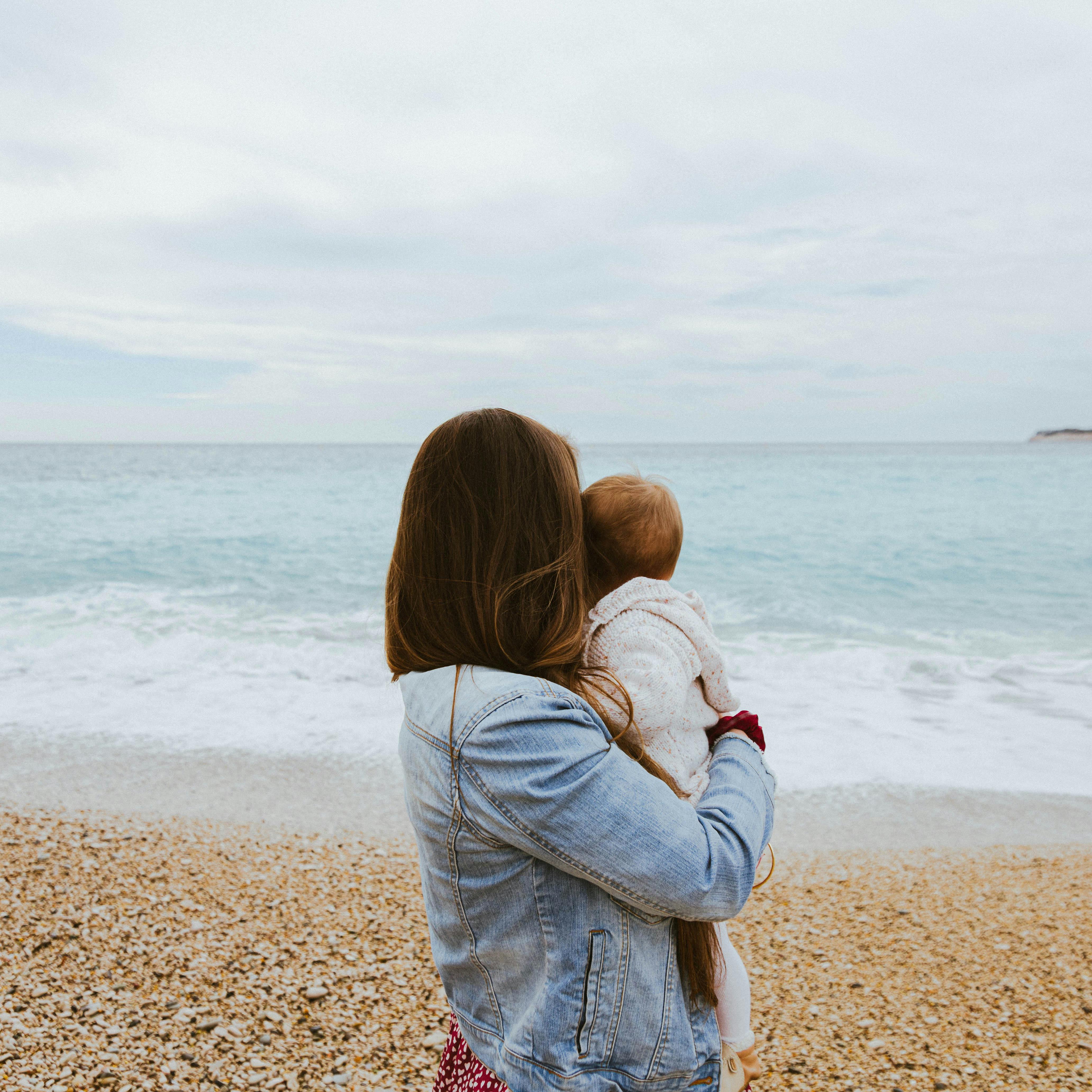 Eine Frau hält ihr Baby am Strand | Quelle: Pexels