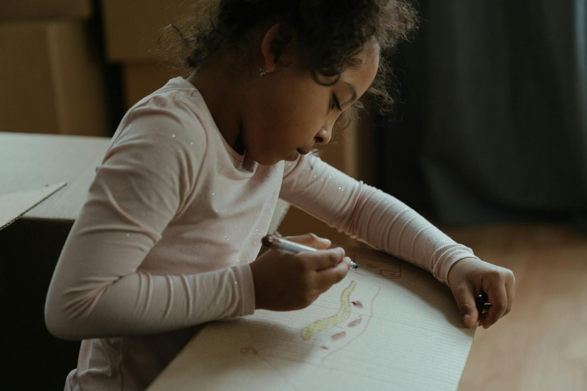 Kind, das auf einen Karton malt | Quelle: Pexels